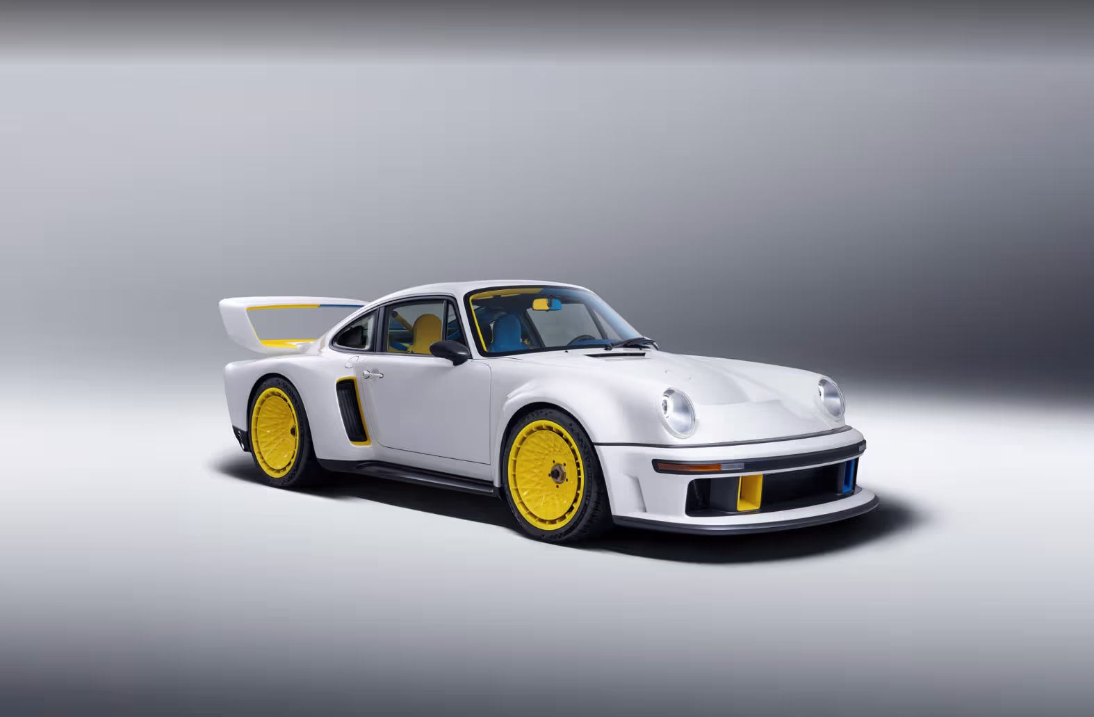 Dianteira agressiva do Singer Porsche 911 DLS Turbo com detalhes azuis e amarelos