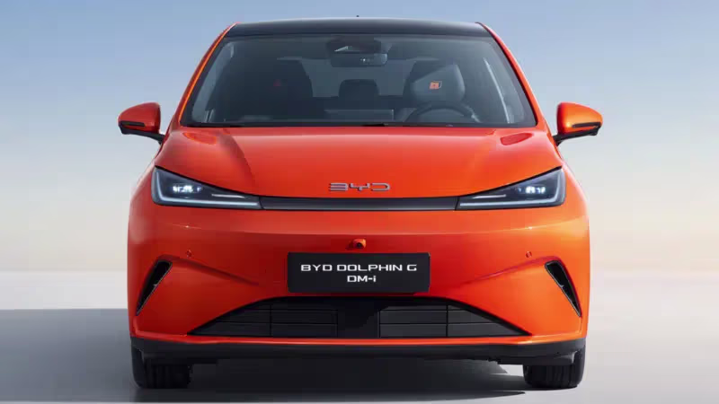 Novo BYD Dolphin G DM-i na cor laranja visto de frente em estúdio