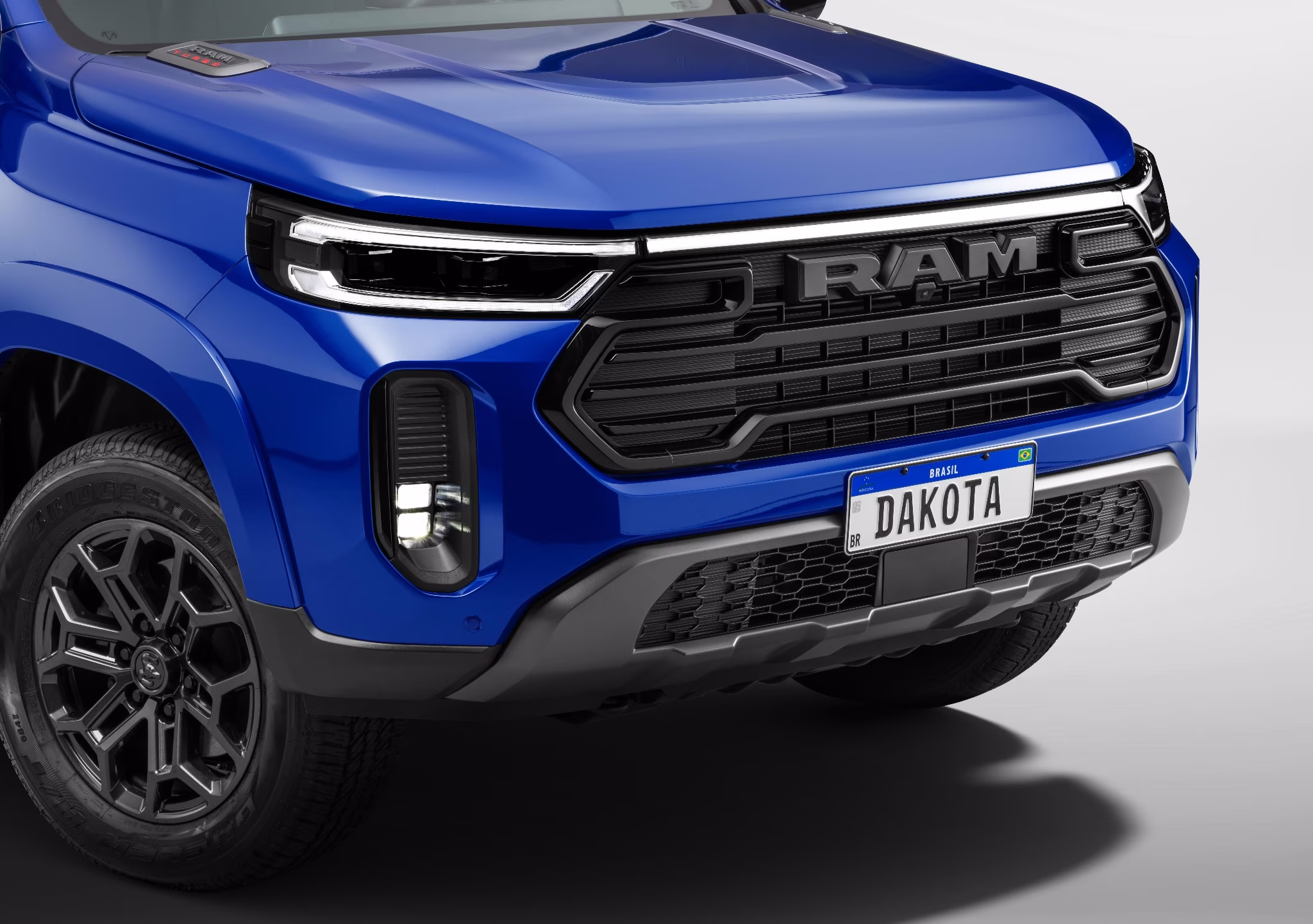 Detalhe frontal da Ram Dakota Laramie Night Edition com grade preta e placa Dakota