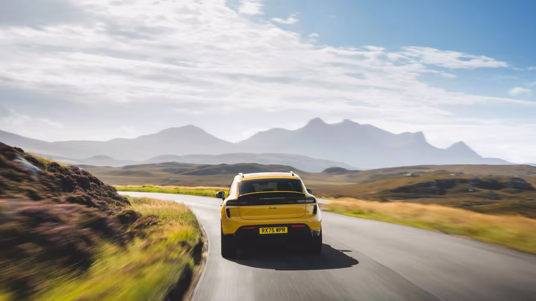 Porsche Macan Turbo elétrico visto de traseira em estrada rural da North Coast 500