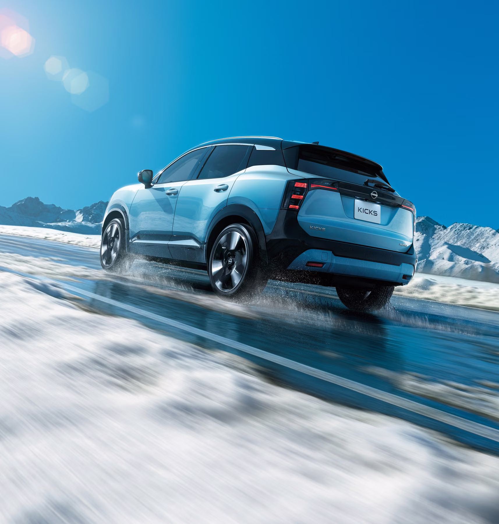 Novo Nissan Kicks azul em movimento em cenário de neve e montanhas