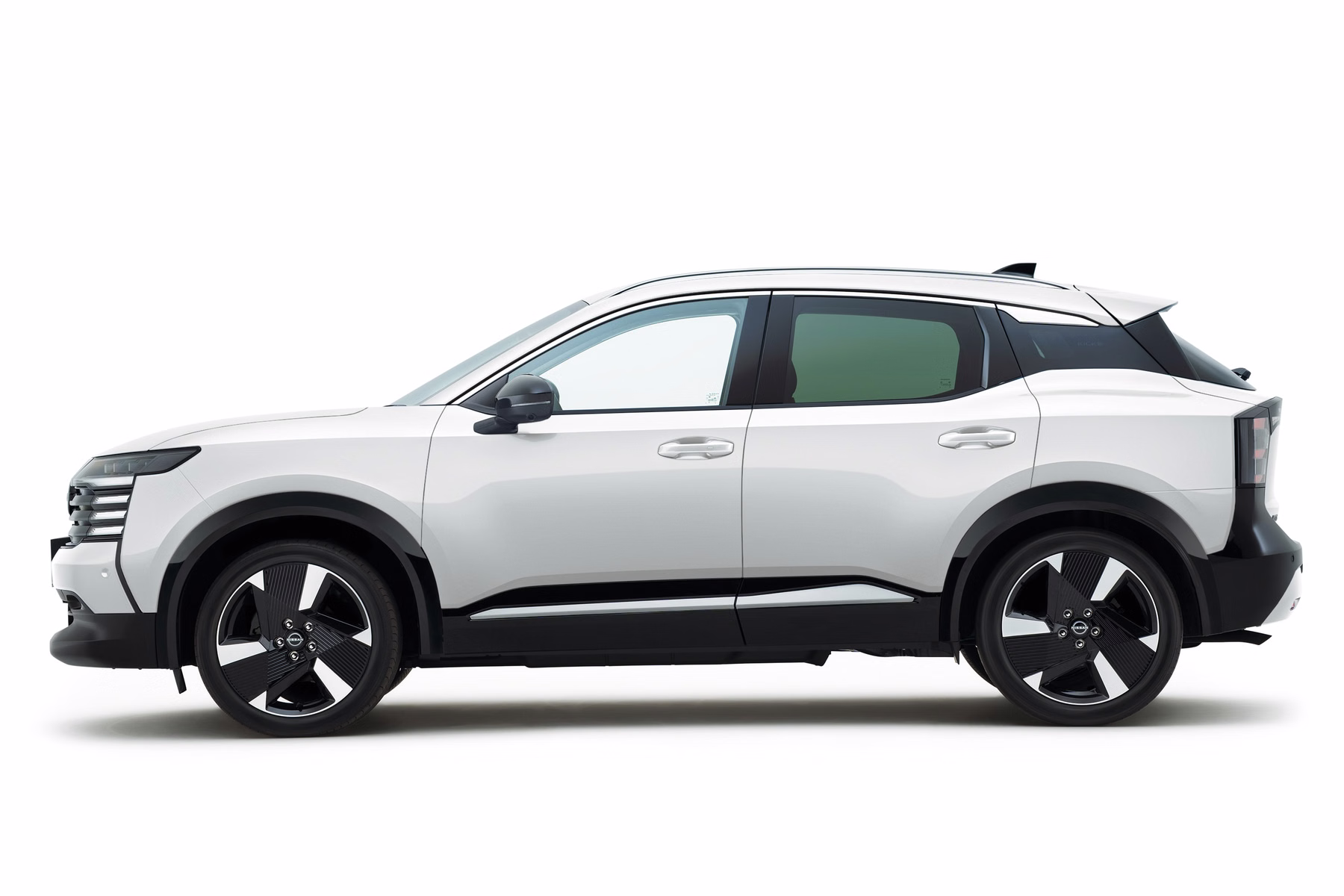 Novo Nissan Kicks branco com teto escuro em vista lateral de estúdio