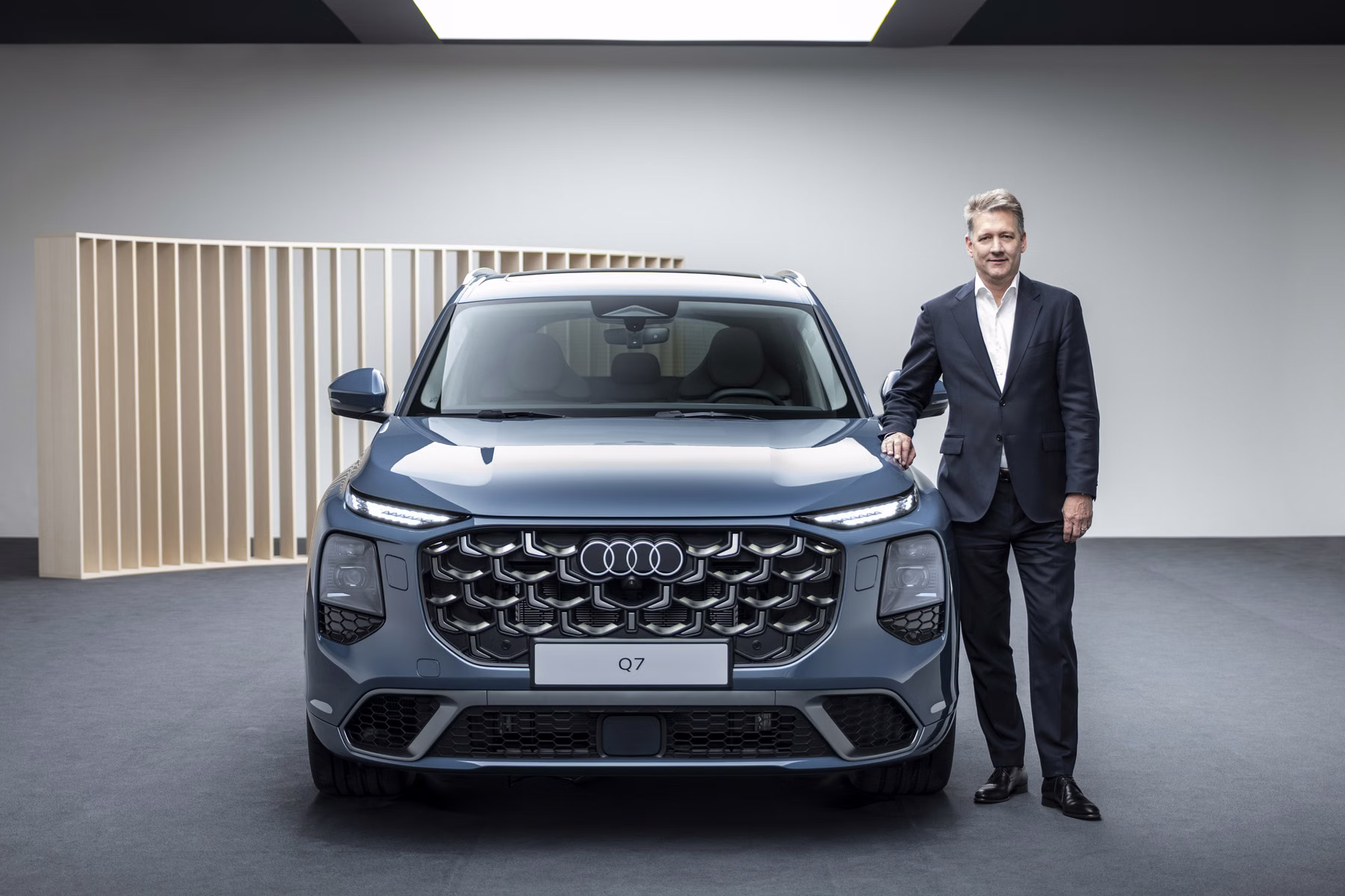 Audi CEO Gernot Döllner ao lado do novo Audi Q7 em estúdio