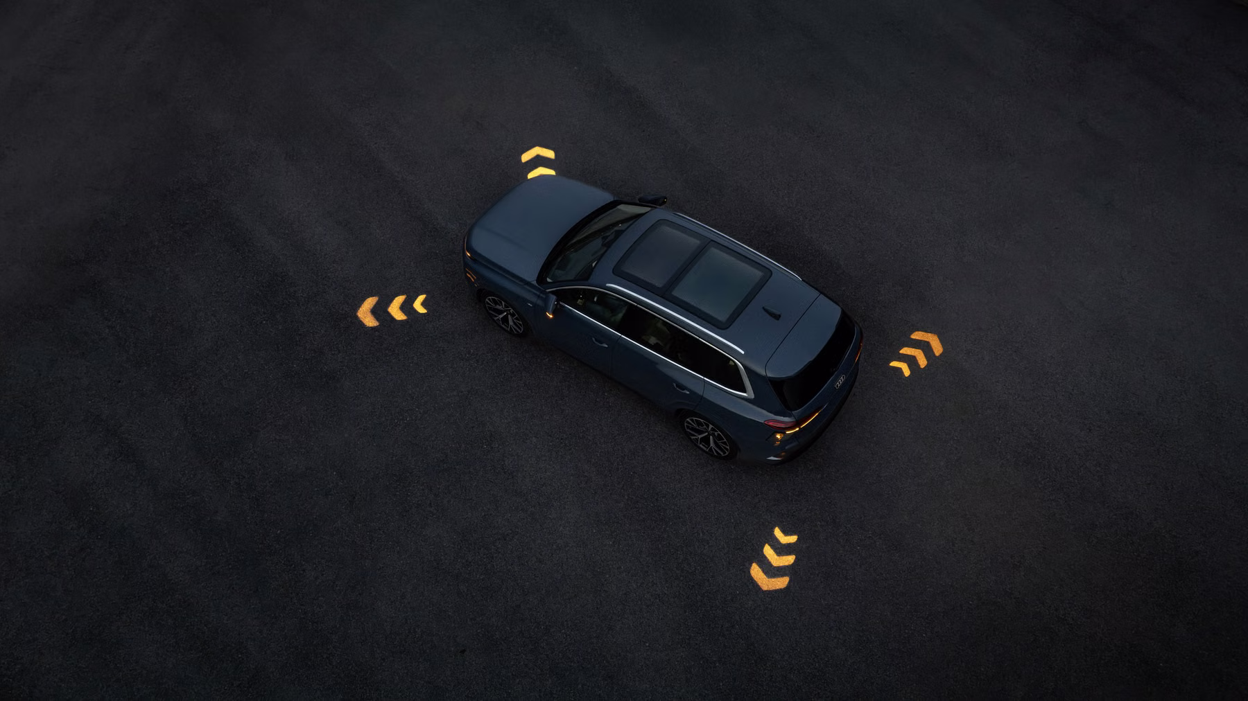 Audi Q7 visto de cima com alertas projetados ao redor do SUV em ambiente escuro