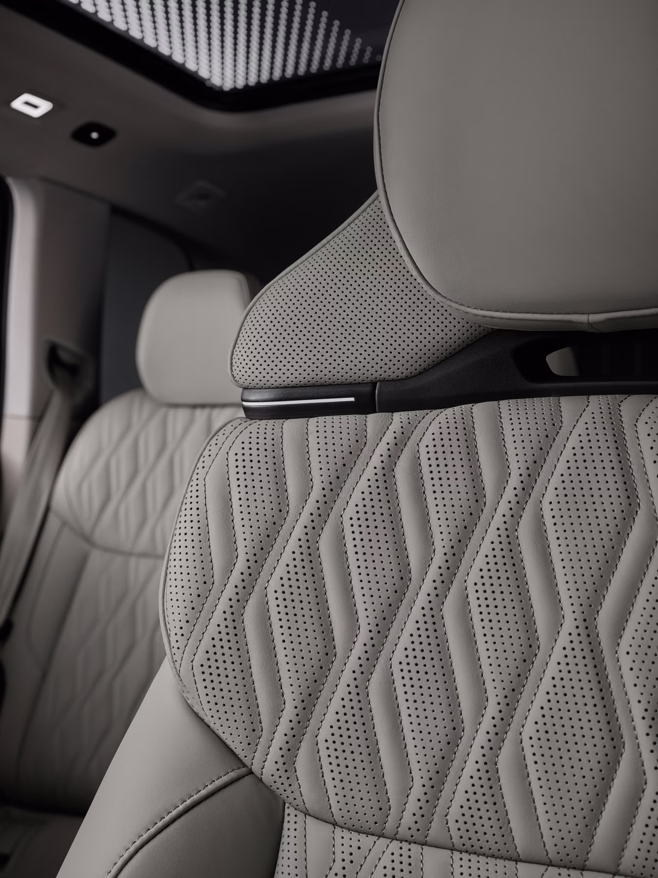 Detalhe do banco dianteiro do Audi Q7 com teto panorâmico ao fundo