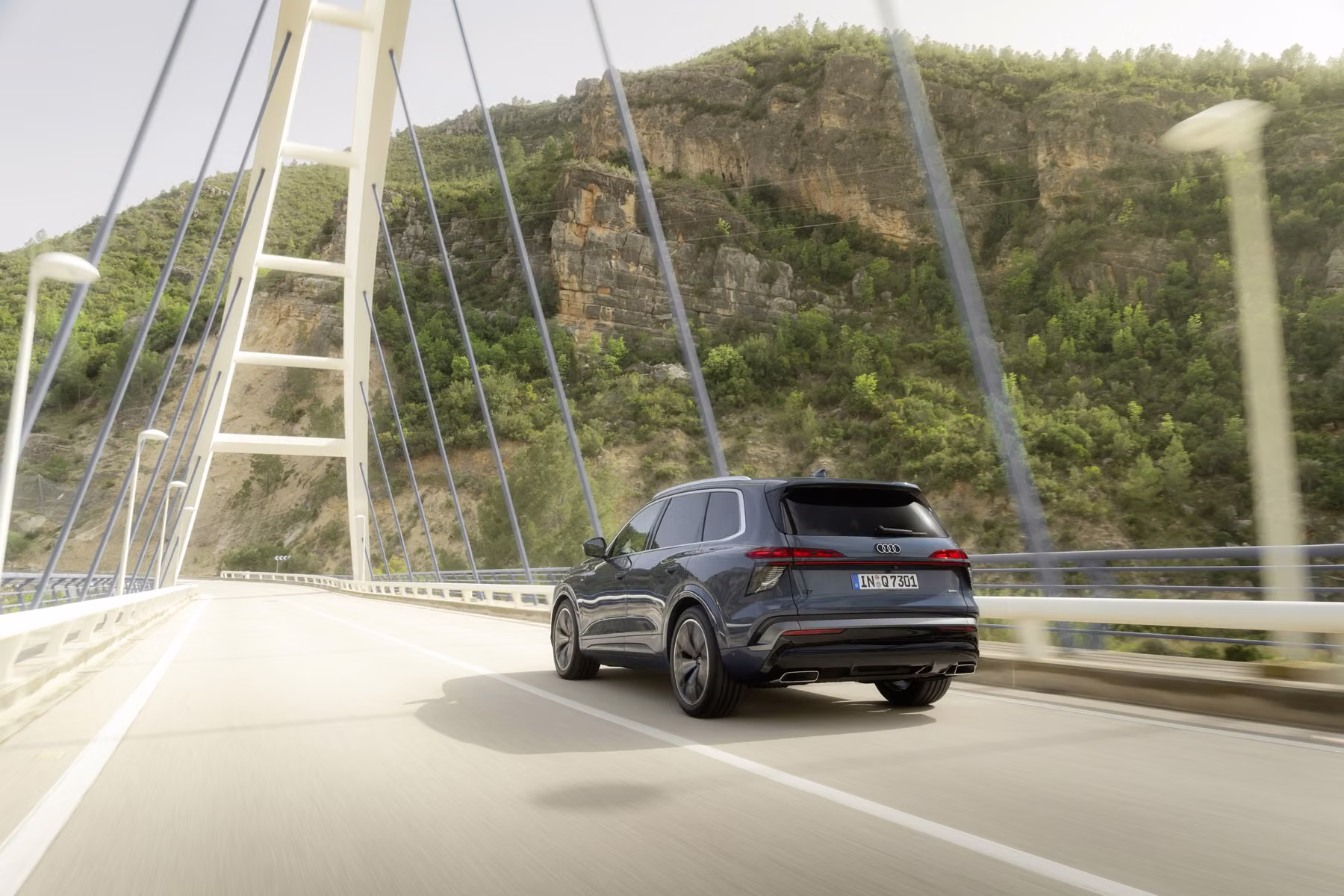 Audi Q7 em movimento sobre ponte com vista traseira