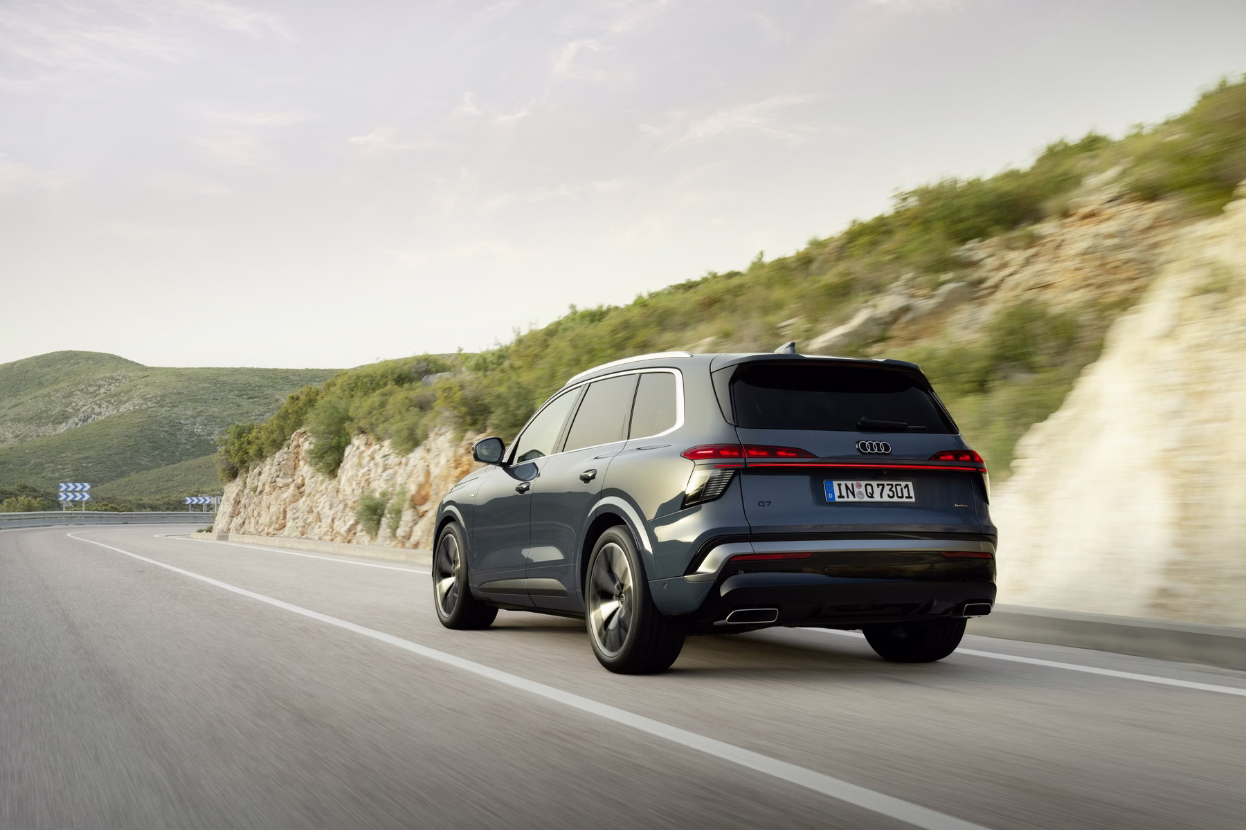 Audi Q7 rodando em estrada aberta visto de três quartos traseira