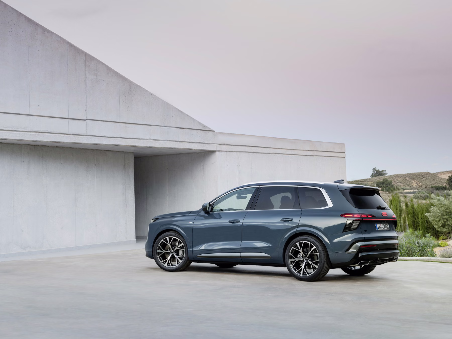 Audi Q7 em vista traseira lateral estacionado em ambiente arquitetônico
