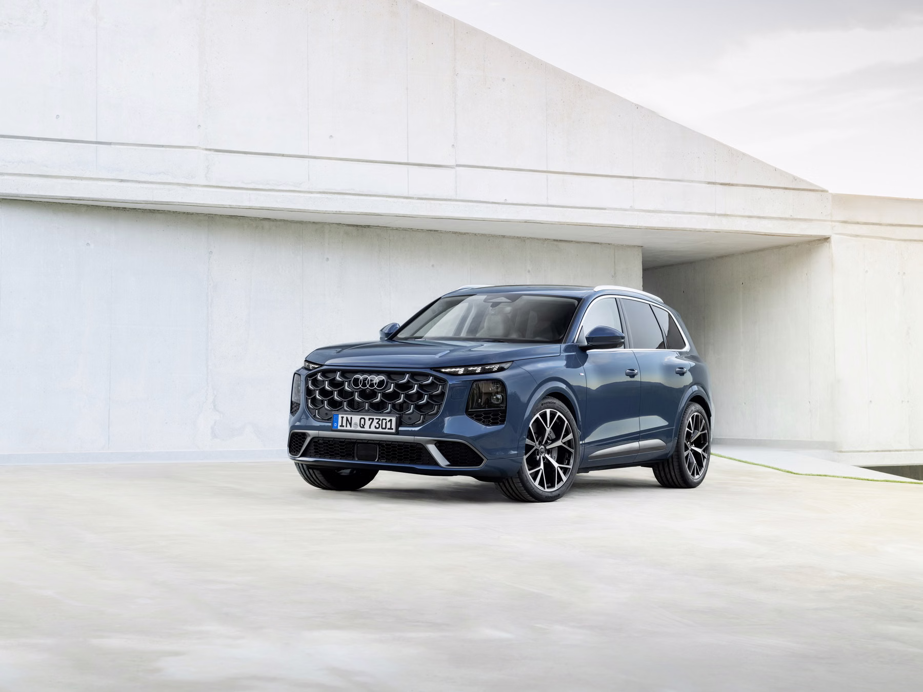 Audi Q7 em vista dianteira lateral em cenário minimalista