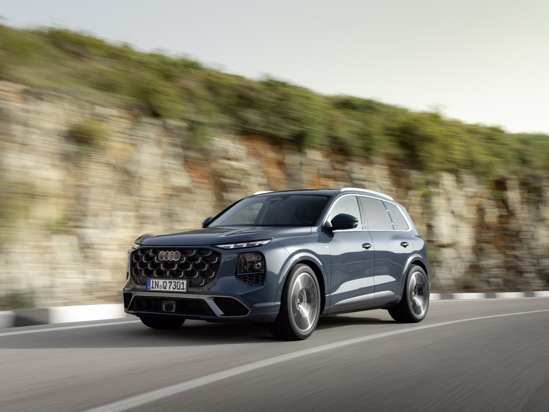 Audi Q7 em movimento em estrada com vista dianteira lateral