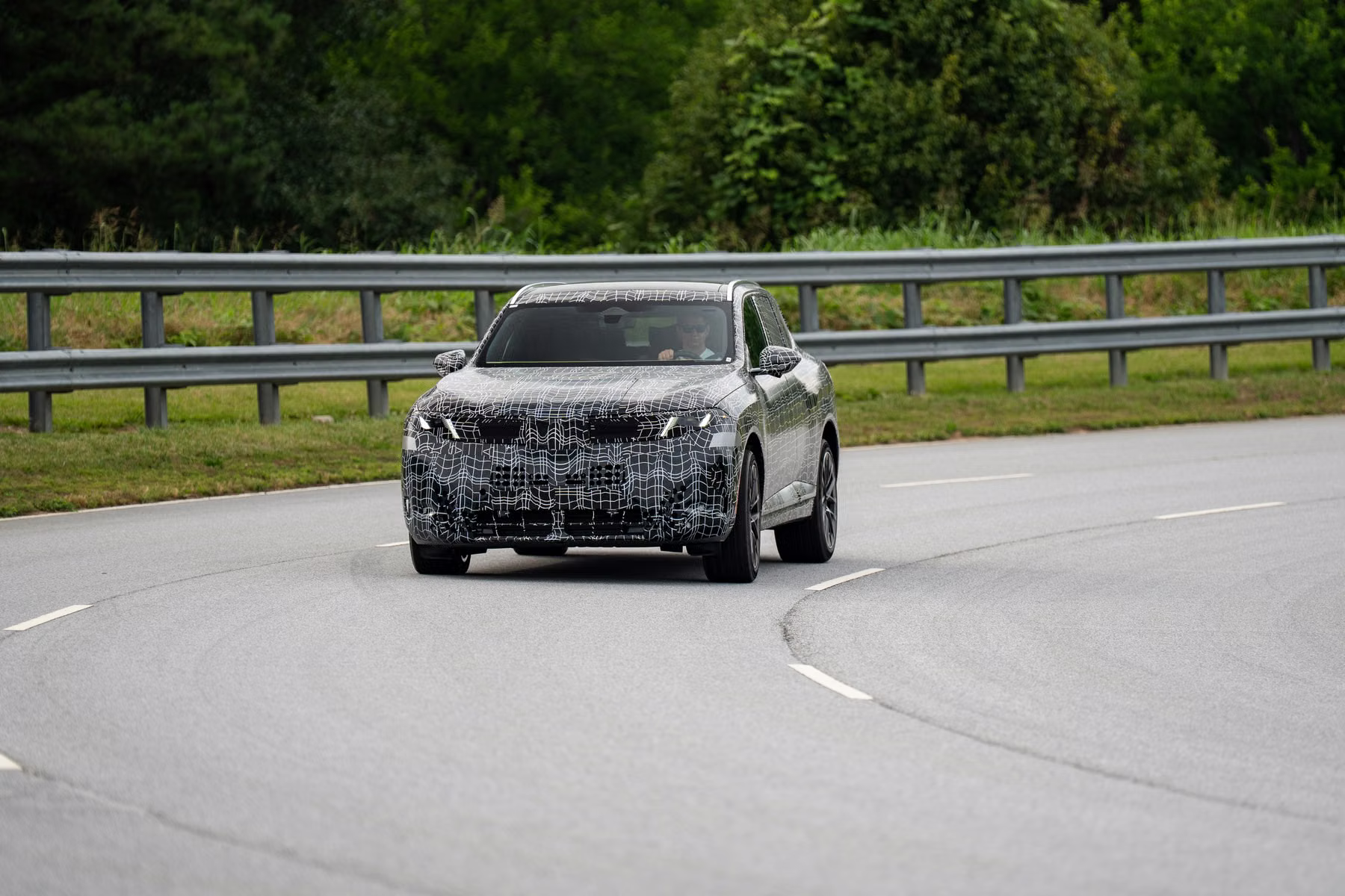 Novo BMW X5 camuflado em curva de pista durante avaliação de chassi