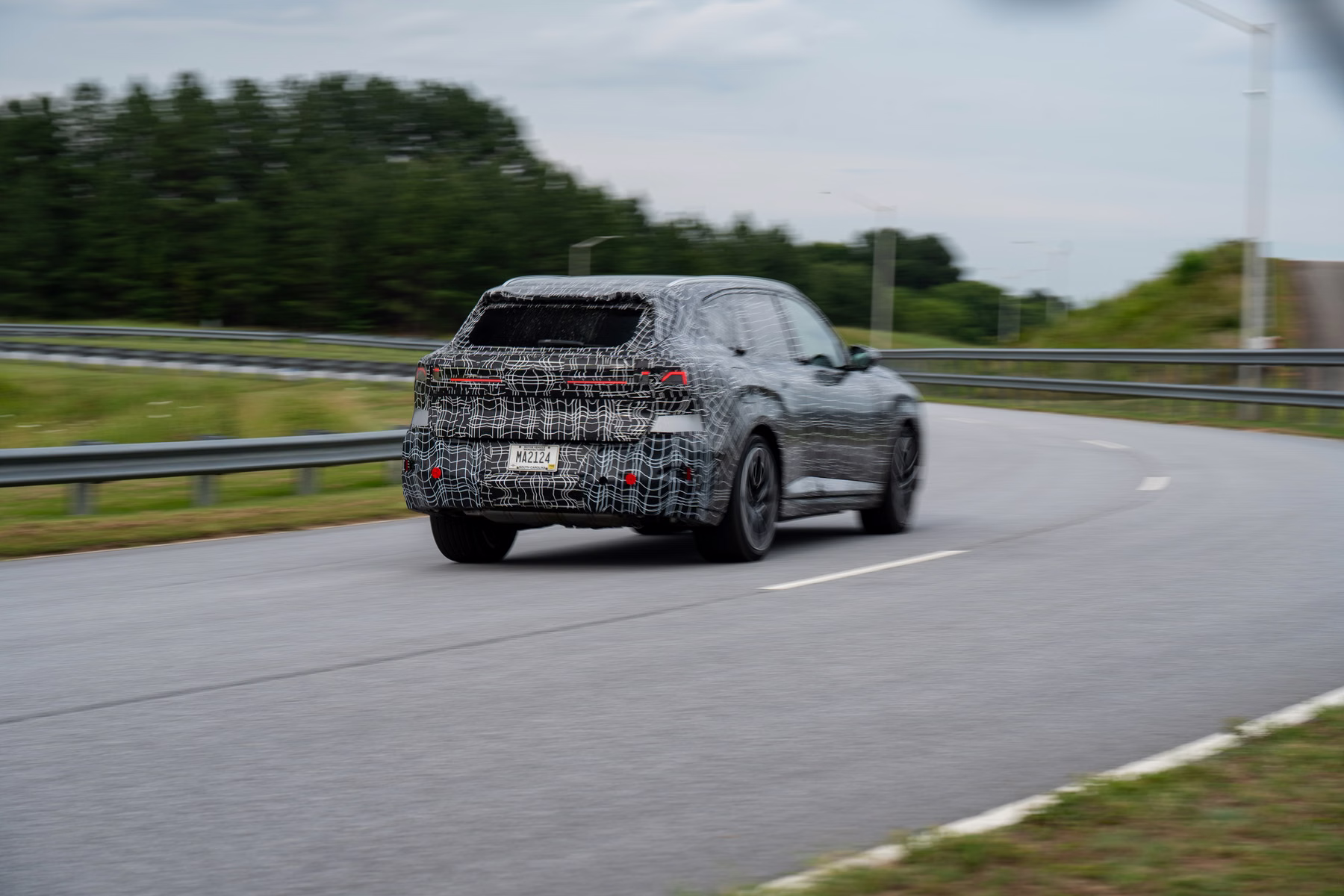 Novo BMW X5 camuflado em rodovia com vista traseira lateral