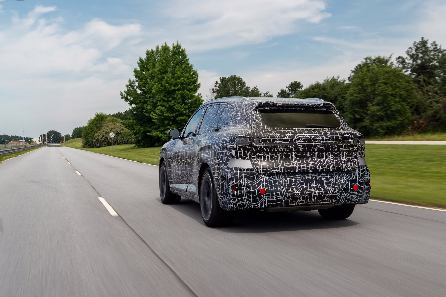 Novo BMW X5 camuflado visto de traseira em rodovia