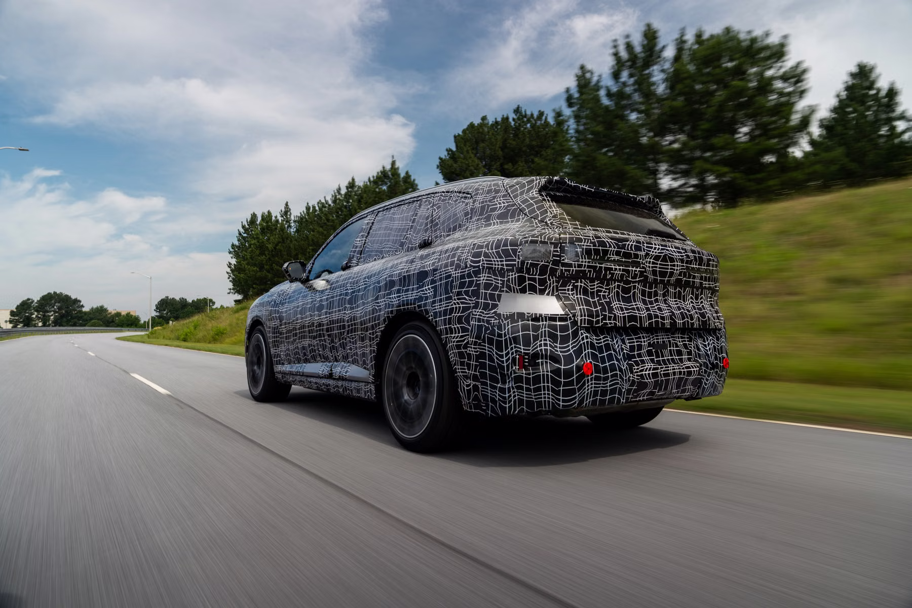 Novo BMW X5 camuflado em rodagem com vista traseira elevada
