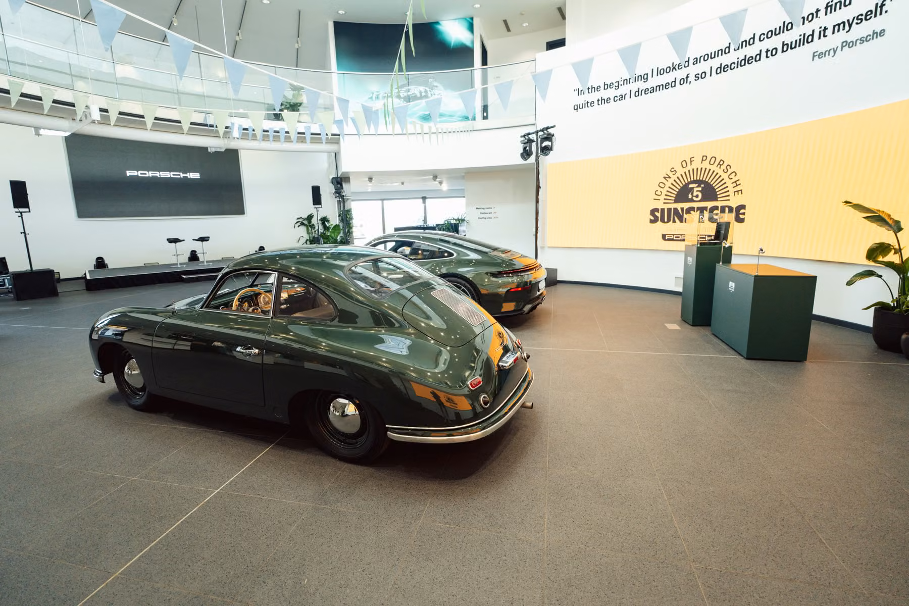 Porsche 356 e Porsche verde em exposição interna no Sunstede Silverstone Edition