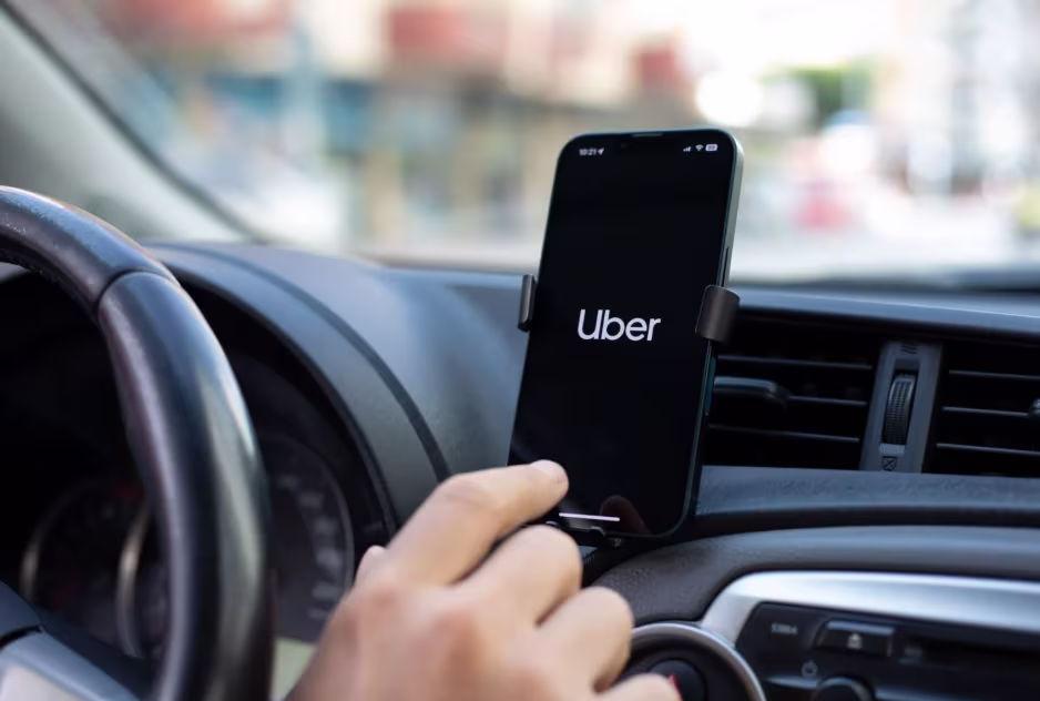 Motorista usando celular com aplicativo em matéria sobre regras do Uber Comfort e Black