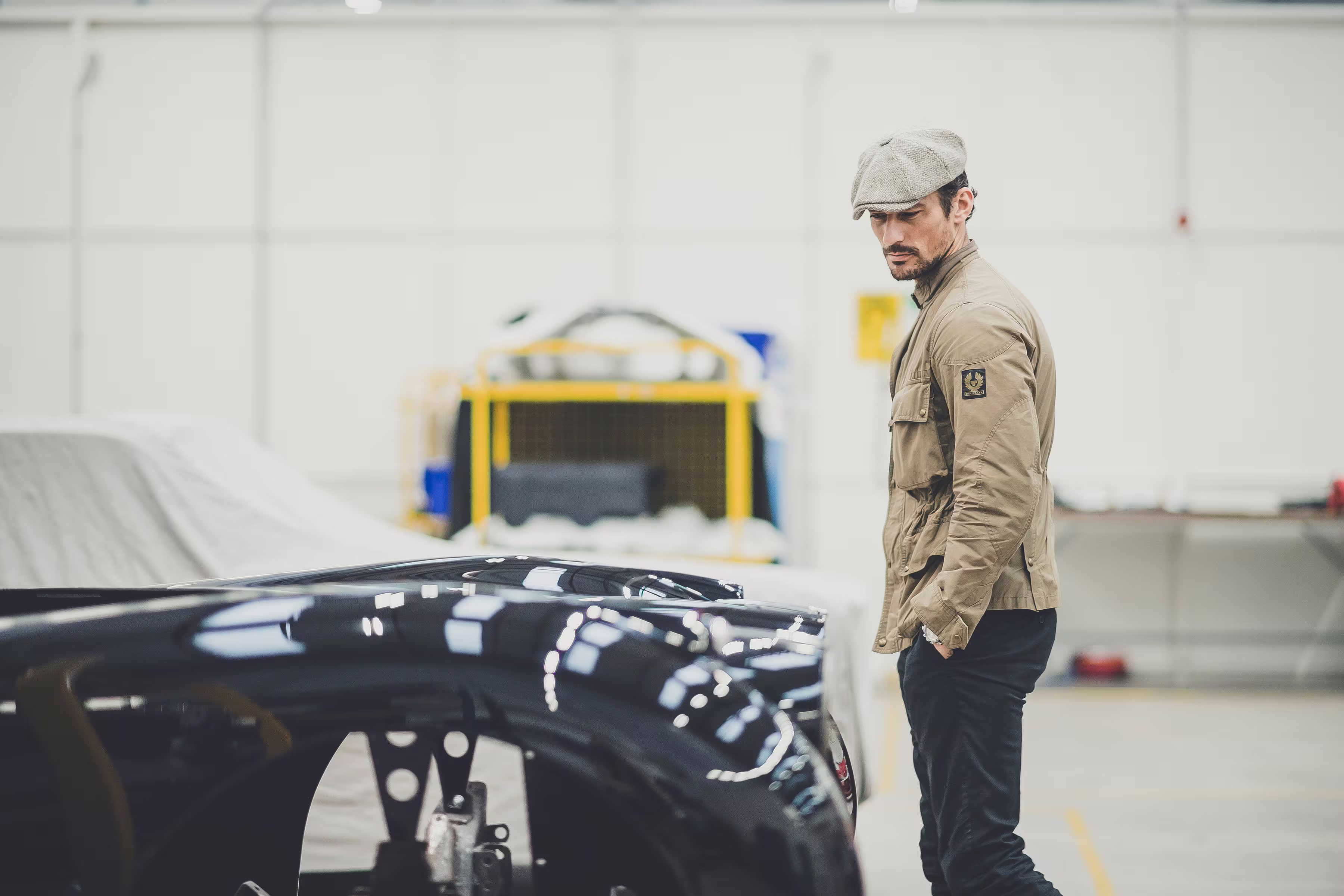 David Gandy observando o para-lama preto do Jaguar XK120 em restauração