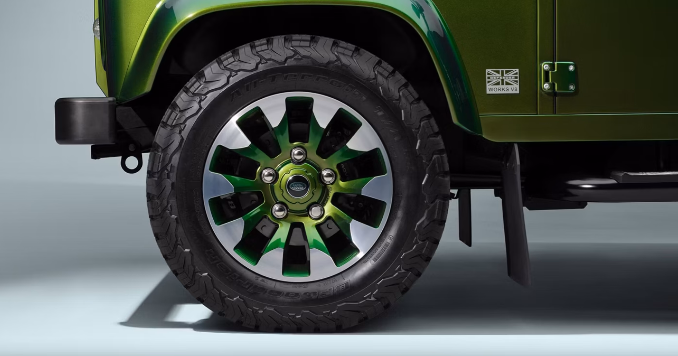 Detalhe da roda do Defender Works Bespoke com miolo verde e pneu mud-terrain