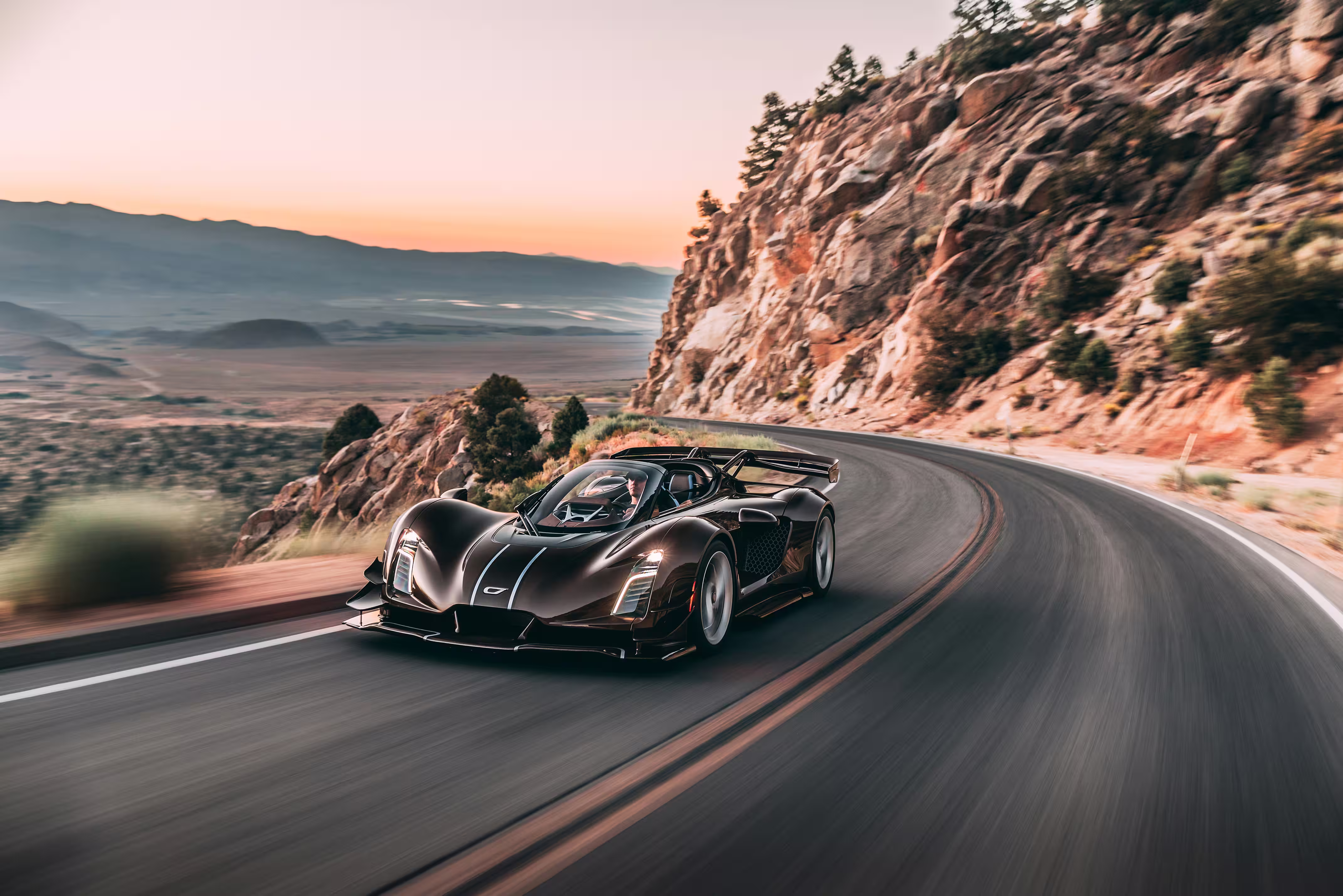 Czinger 21C Spyder em movimento numa estrada de montanha ao entardecer