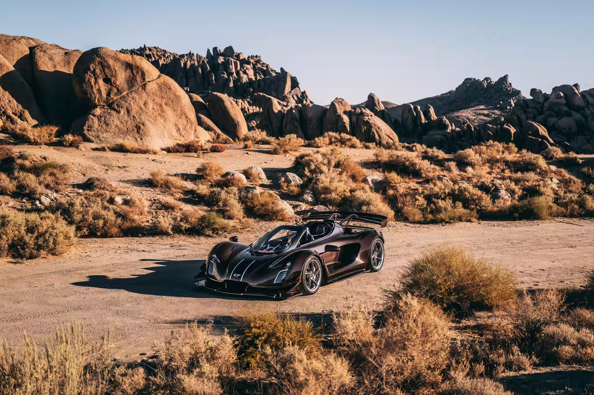 Czinger 21C Spyder parado no deserto visto de frente e de lado