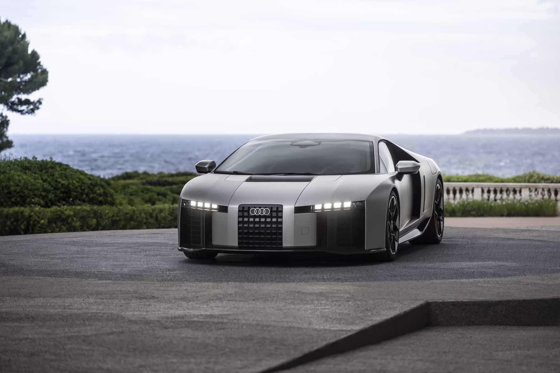 Audi Nuvolari visto de três quartos dianteiros diante do mar em Pebble Beach