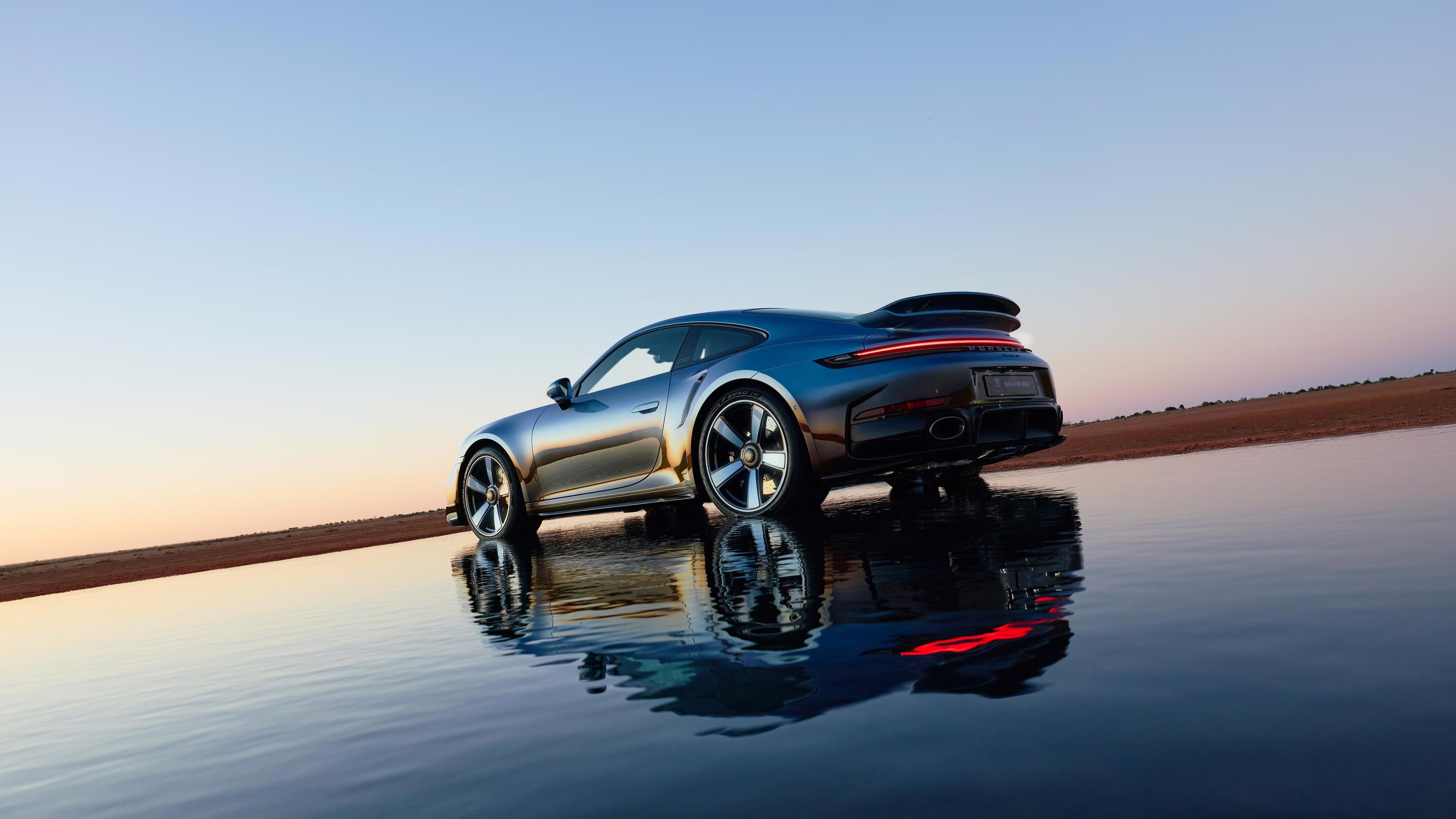 Porsche 911 Turbo S Land Down Under refletido sobre uma lâmina de água