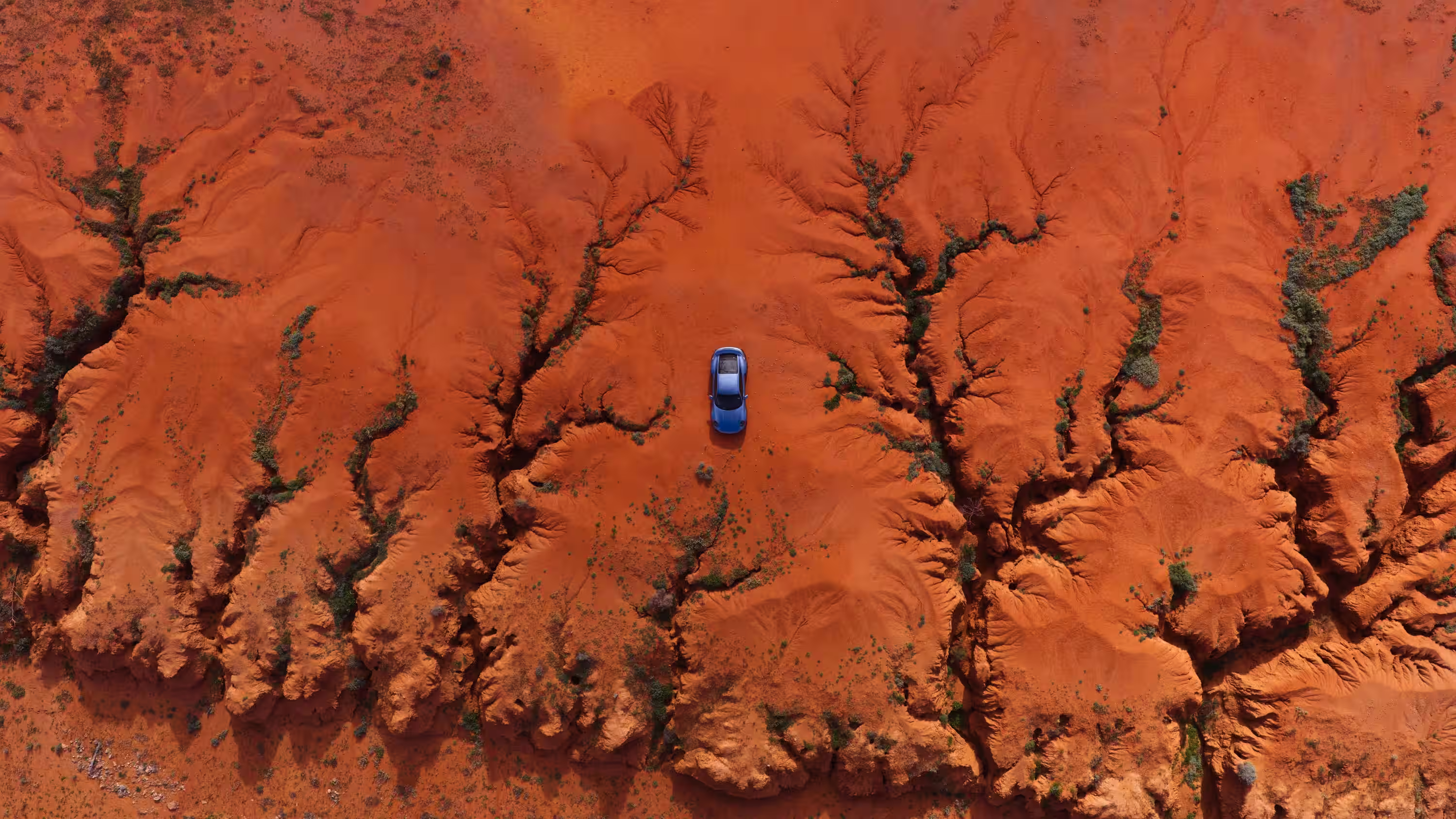 Vista aérea do Porsche 911 Turbo S Land Down Under no solo vermelho australiano