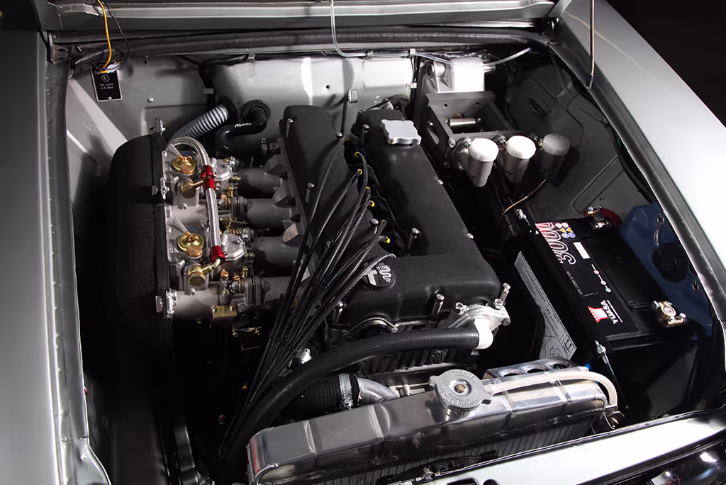 Alfa Romeo Giulia Super 1972 branco em três quartos frontal na oficina Alfaholics