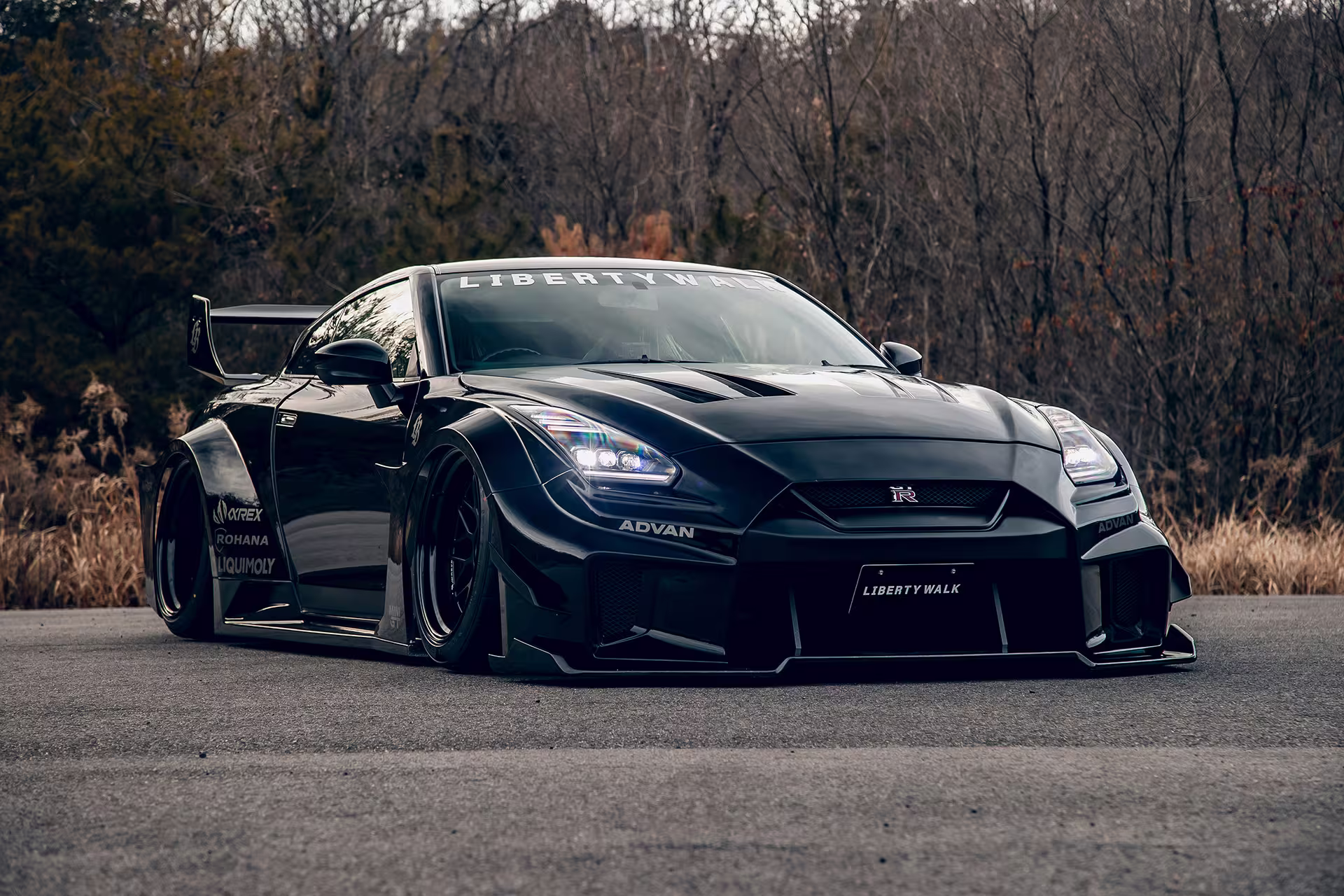 LB-Silhouette WORKS GT preto em perfil em estacionamento ao entardecer