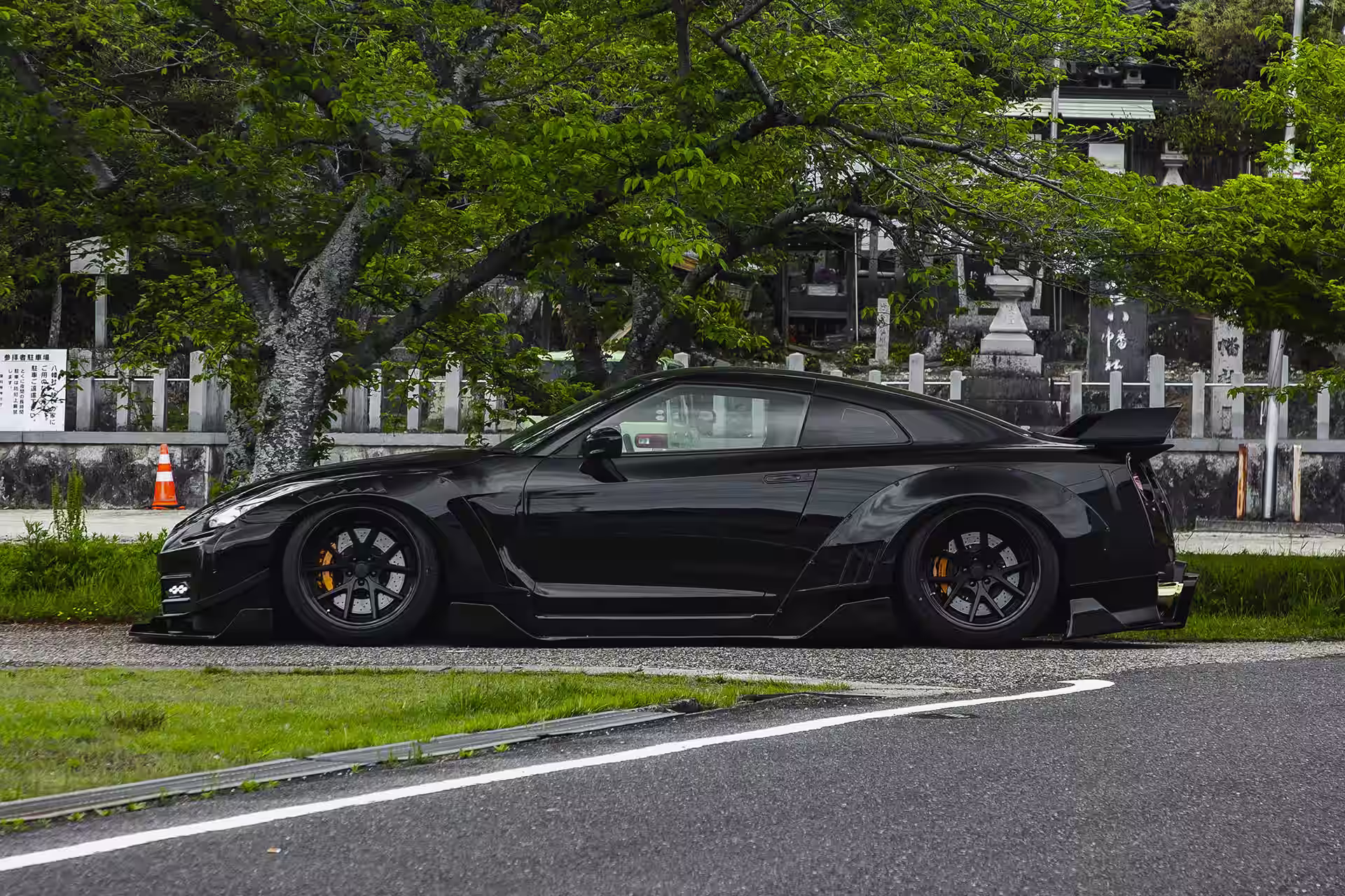 LB-WORKS GT Nissan 35GT-R Final Edition preto parado em ambiente arborizado