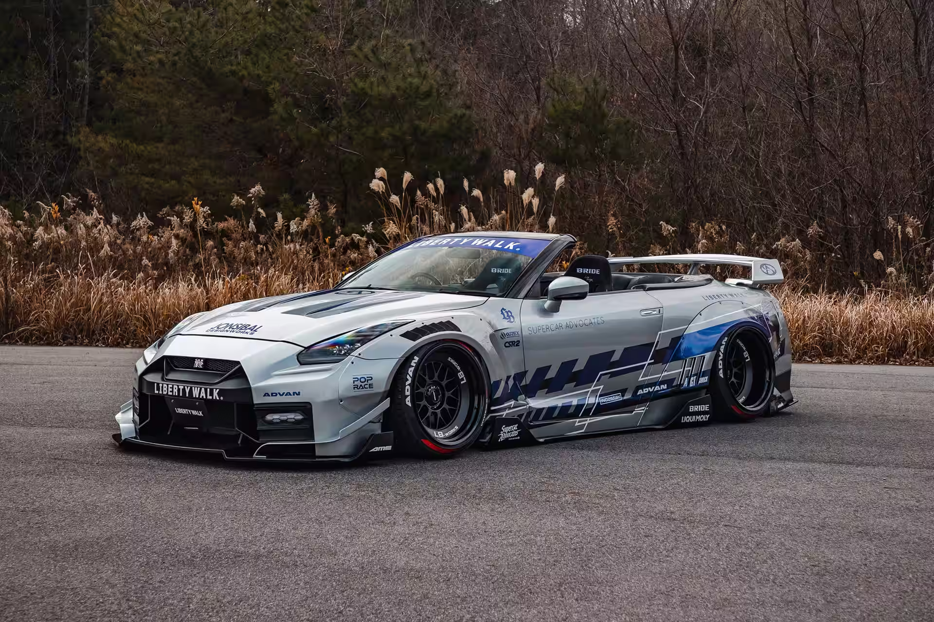 LB-WORKS GT Nissan 35GT-R Final Edition prata com grafismo azul em campo aberto ao entardecer