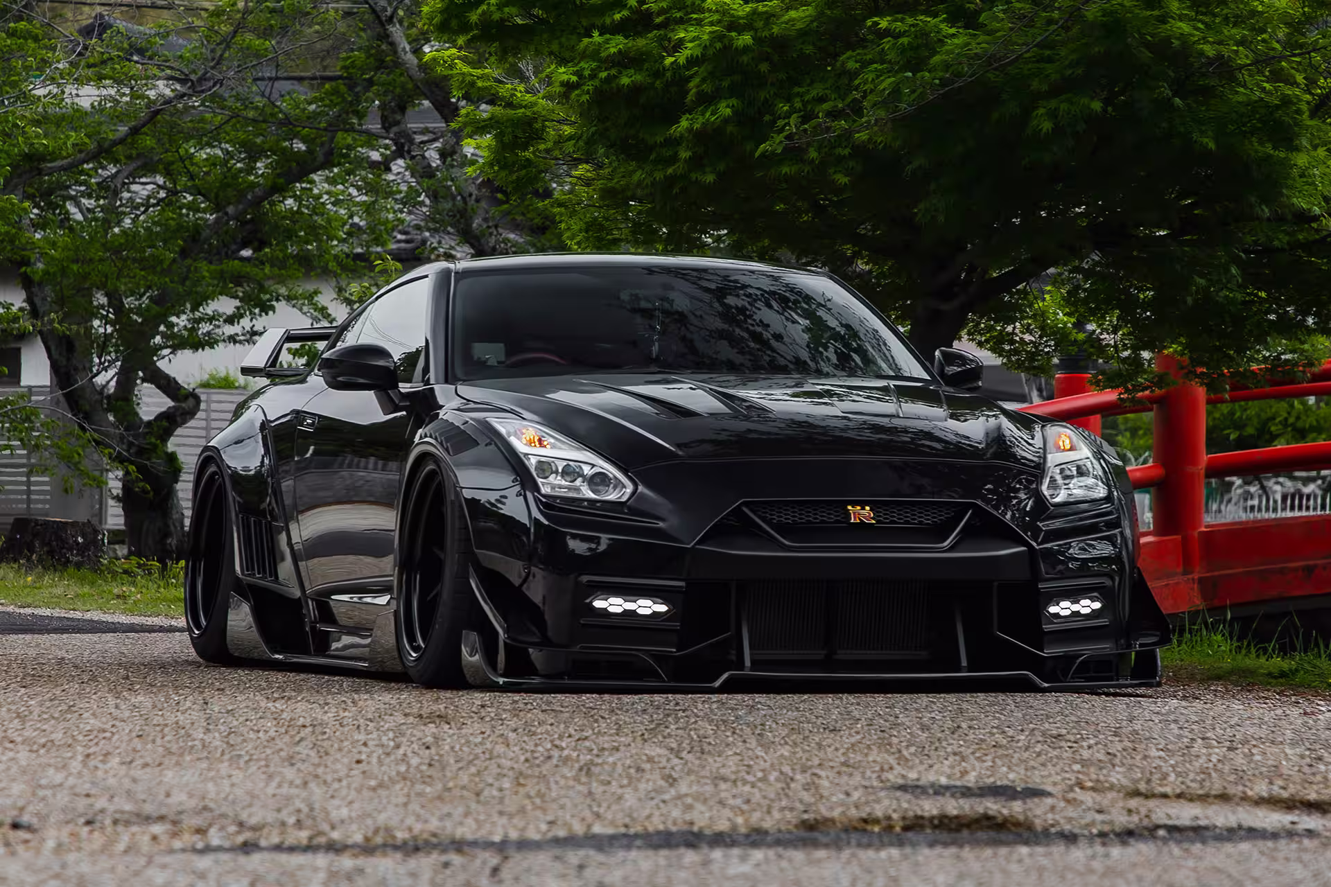 LB-WORKS GT Nissan 35GT-R Final Edition preto em três-quartos frontal com portal torii vermelho ao fundo
