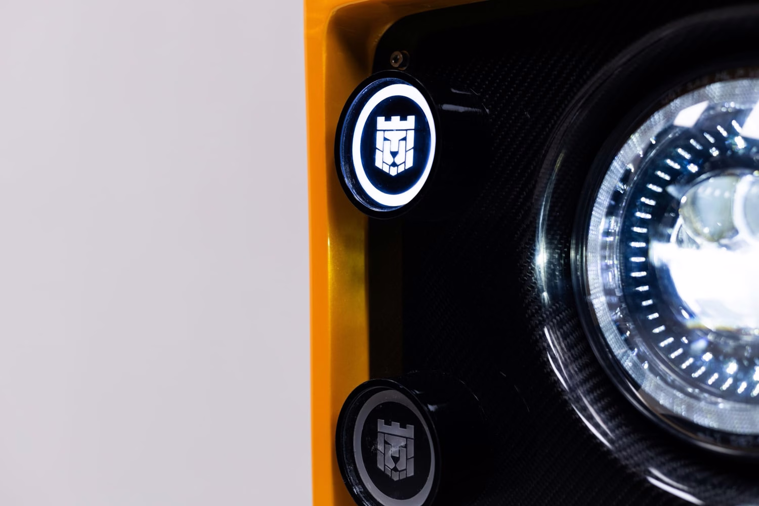 Detalhe do farol e do emblema iluminado do Monarch Defender Lunaro