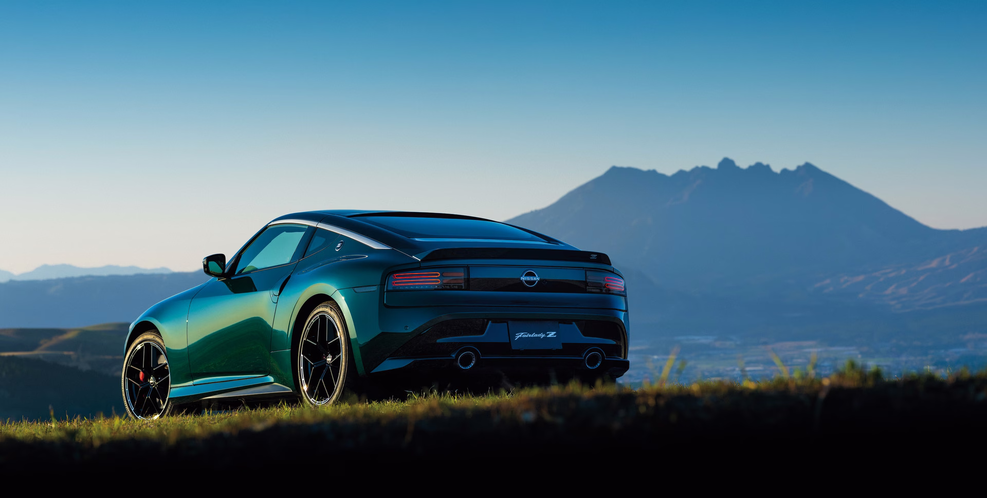 Nissan Fairlady Z verde visto de traseira em paisagem montanhosa