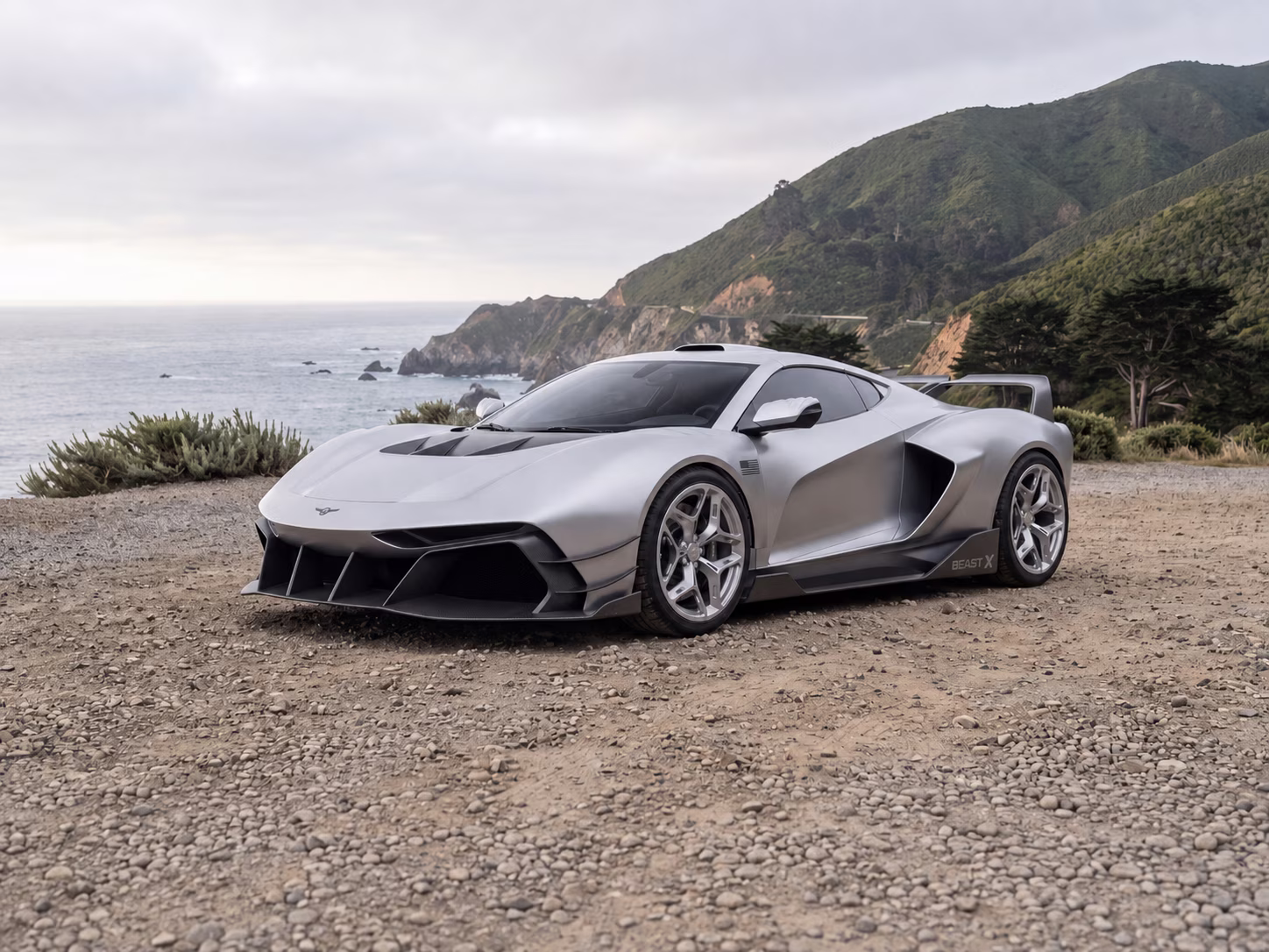 Rezvani Beast X visto em três quartos dianteiros com o oceano ao fundo