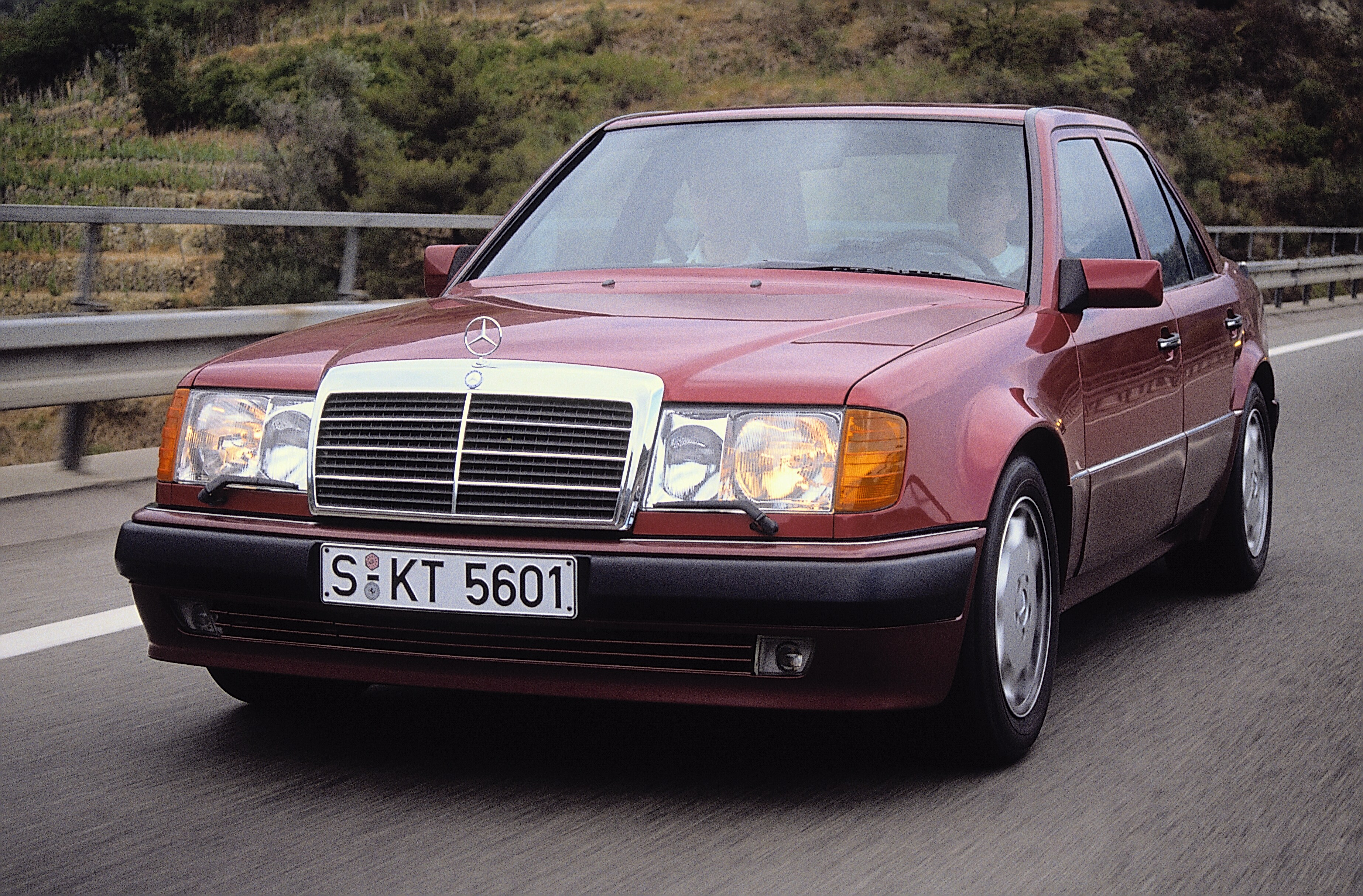 Foto de divulgação de 1990 de um Mercedes-Benz 500 E vermelho em movimento