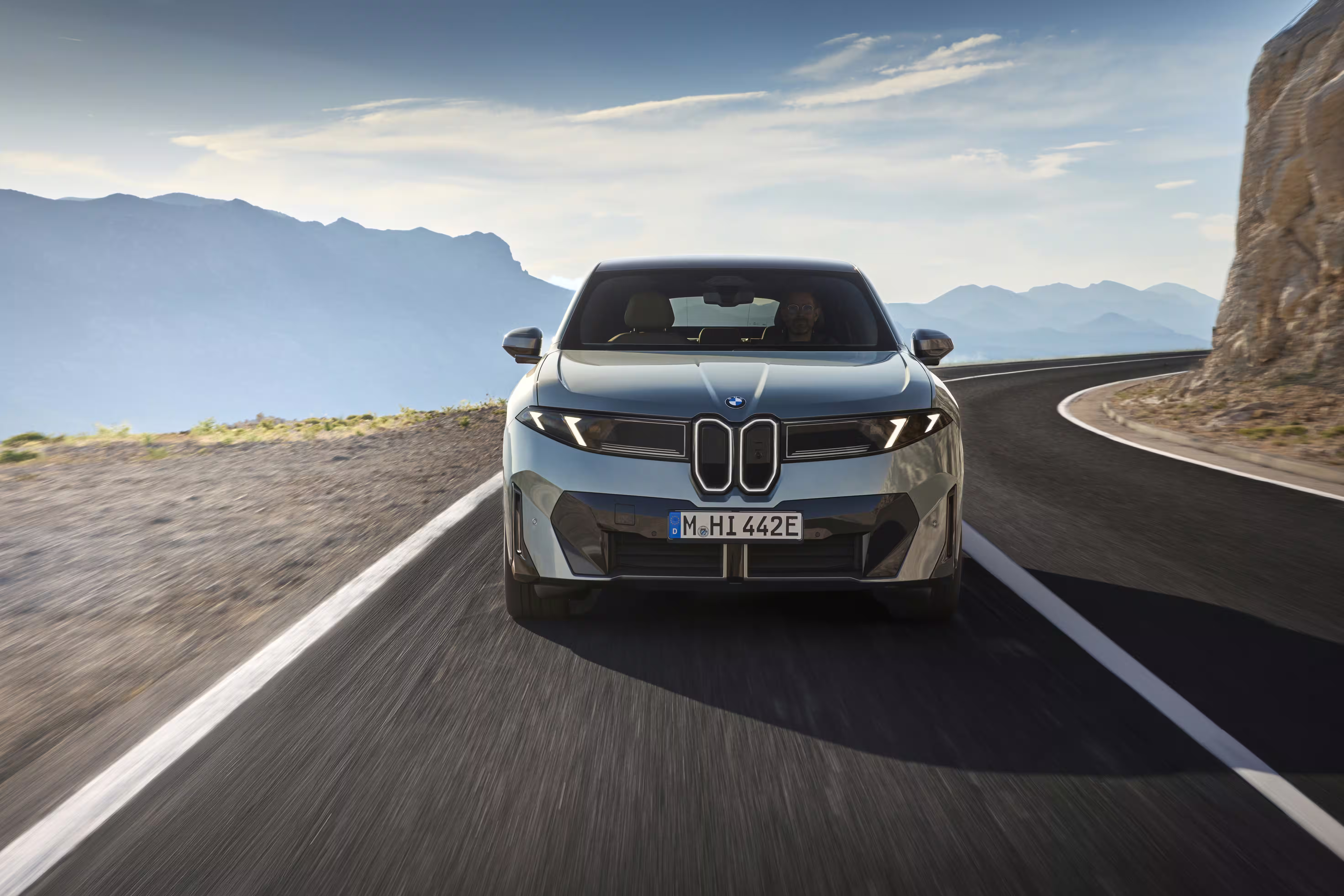 Foto de divulgação da BMW: Vista frontal direta do 50 xDrive em movimento, sem o conjunto luminoso amarelo do M60.