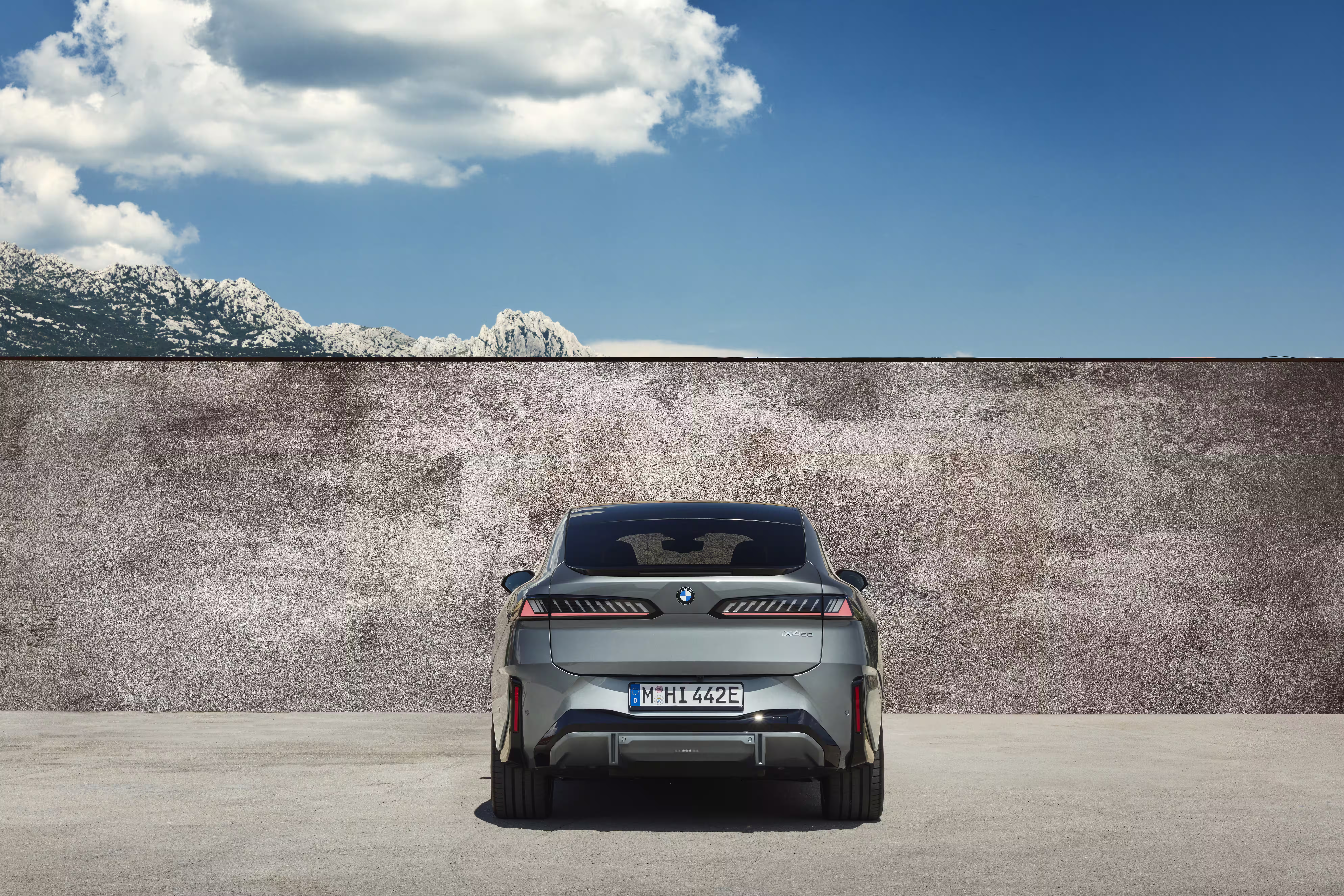 Foto de divulgação da BMW: Vista traseira direta do 50 xDrive junto à parede, com a tampa fechada.