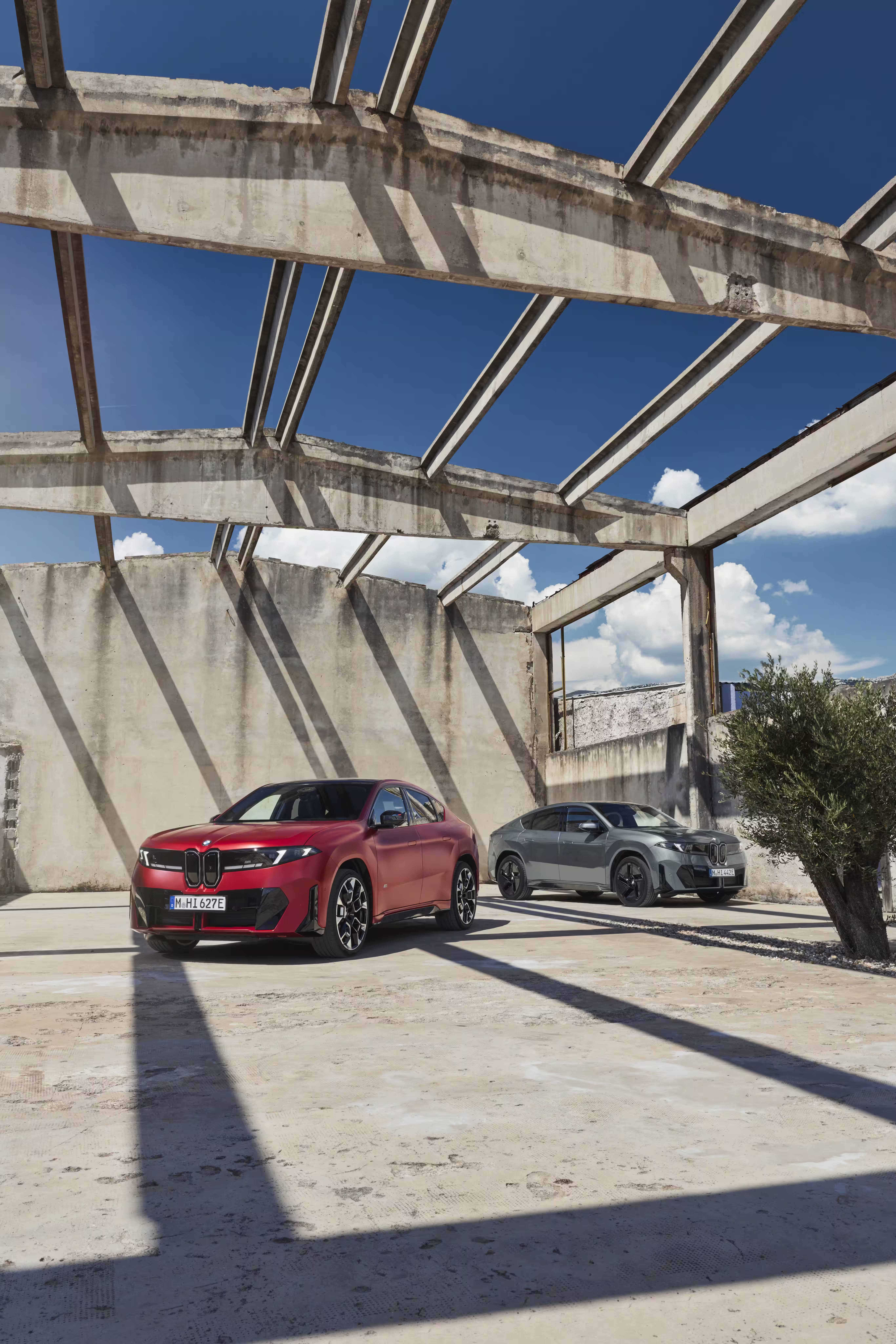 Foto de divulgação da BMW: Foto vertical com M60 e 50 xDrive no mesmo enquadramento diante da construção.