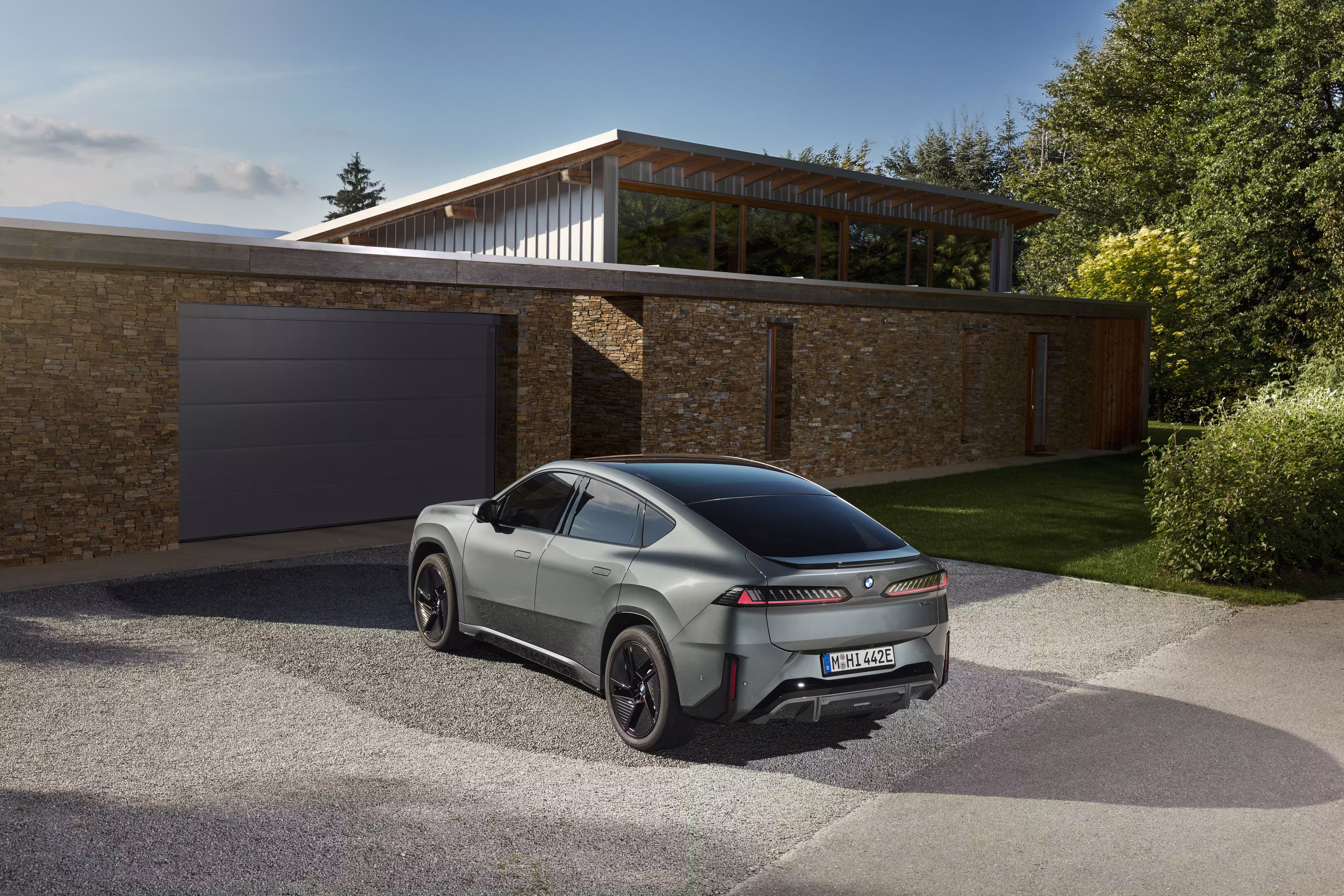 Foto de divulgação da BMW: Outro enquadramento traseiro do 50 xDrive no ambiente residencial.