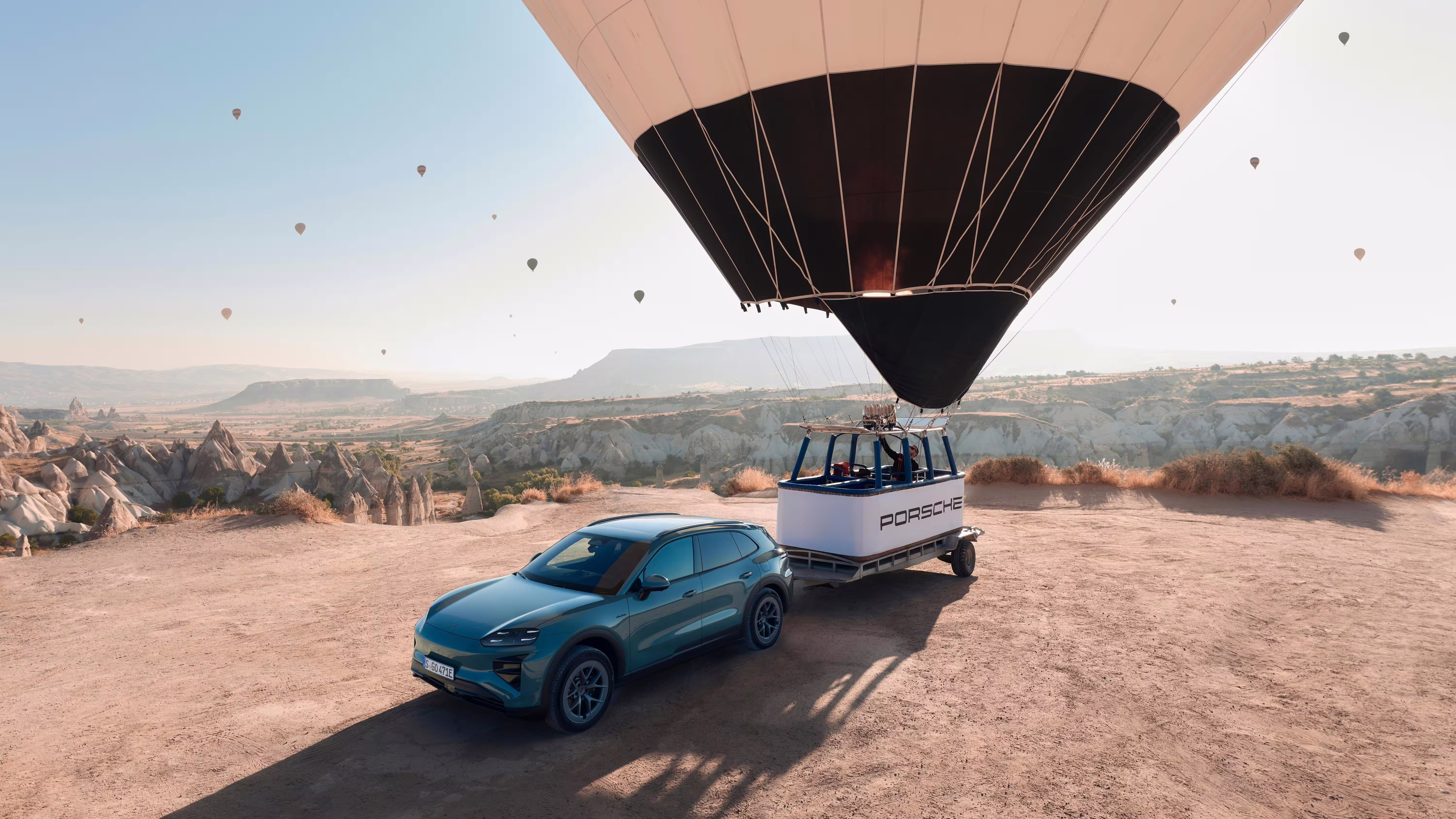 Vista elevada de Cayenne Electric azul com reboque sob o cesto de um balão