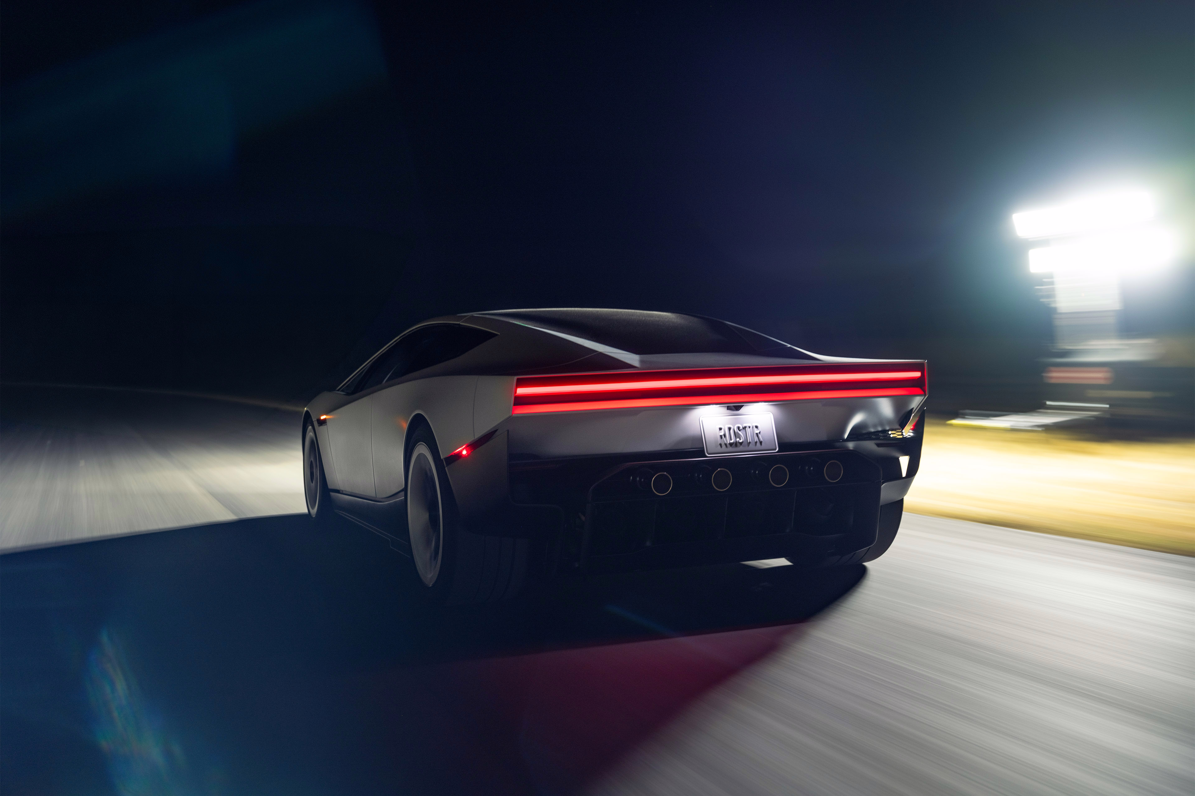 Roadster visto pela traseira em cena dinâmica de pista noturna