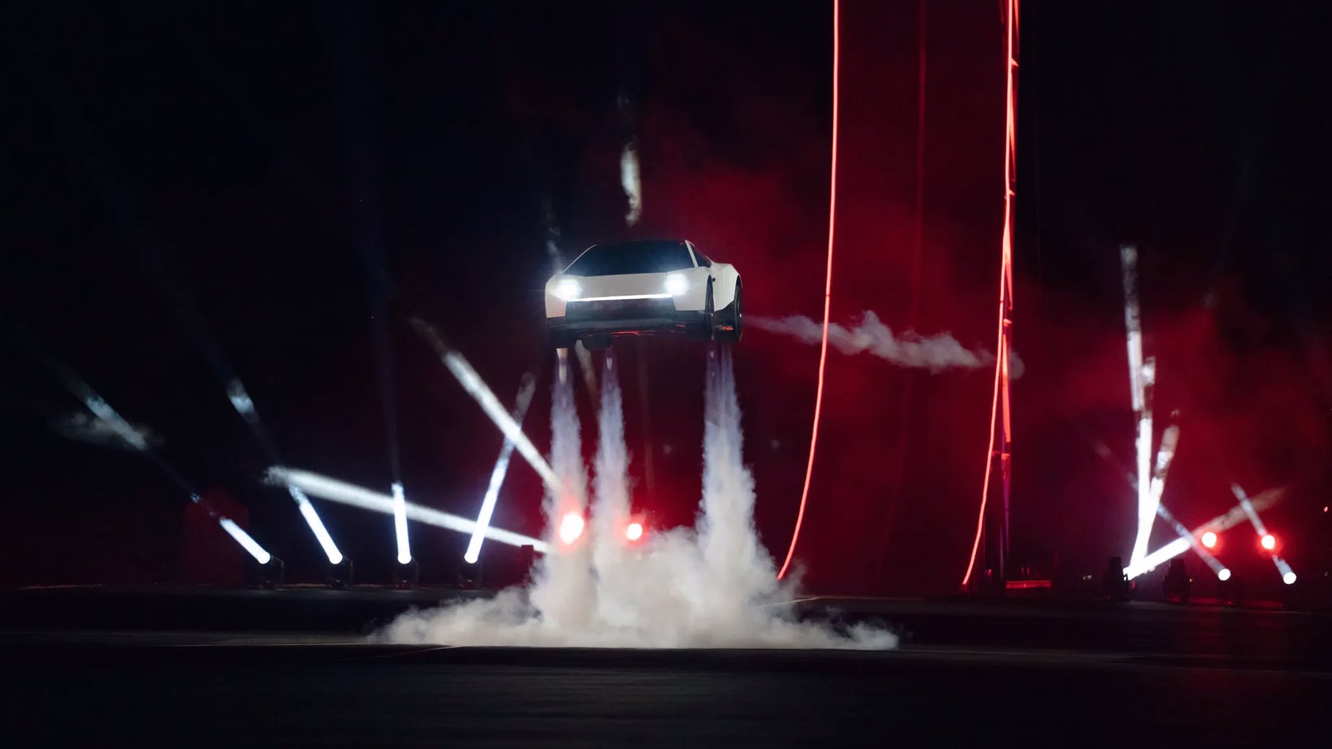 Registro do Tesla Roadster suspenso acima do palco com jatos voltados para baixo
