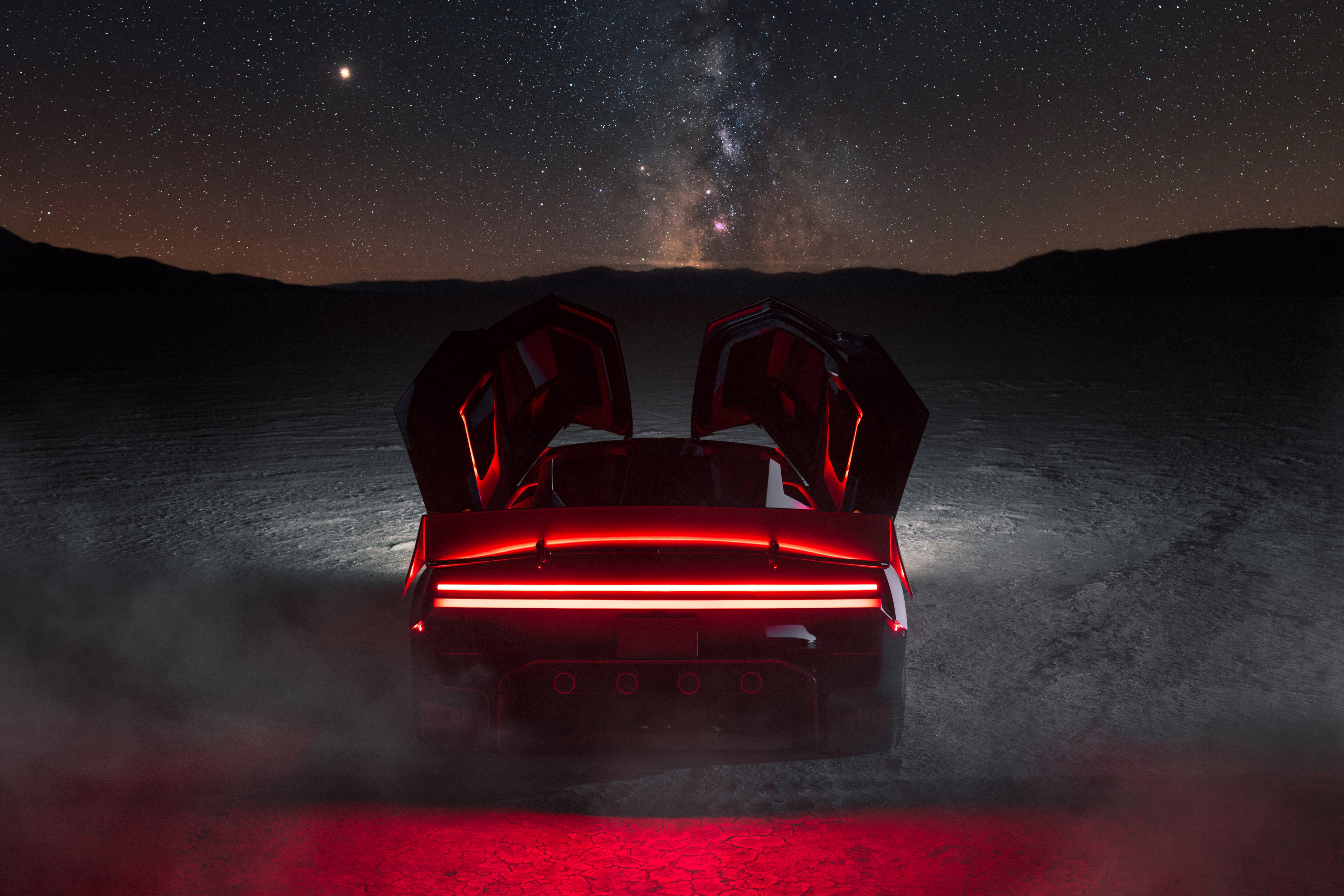 Roadster visto por trás com portas abertas sob um céu estrelado