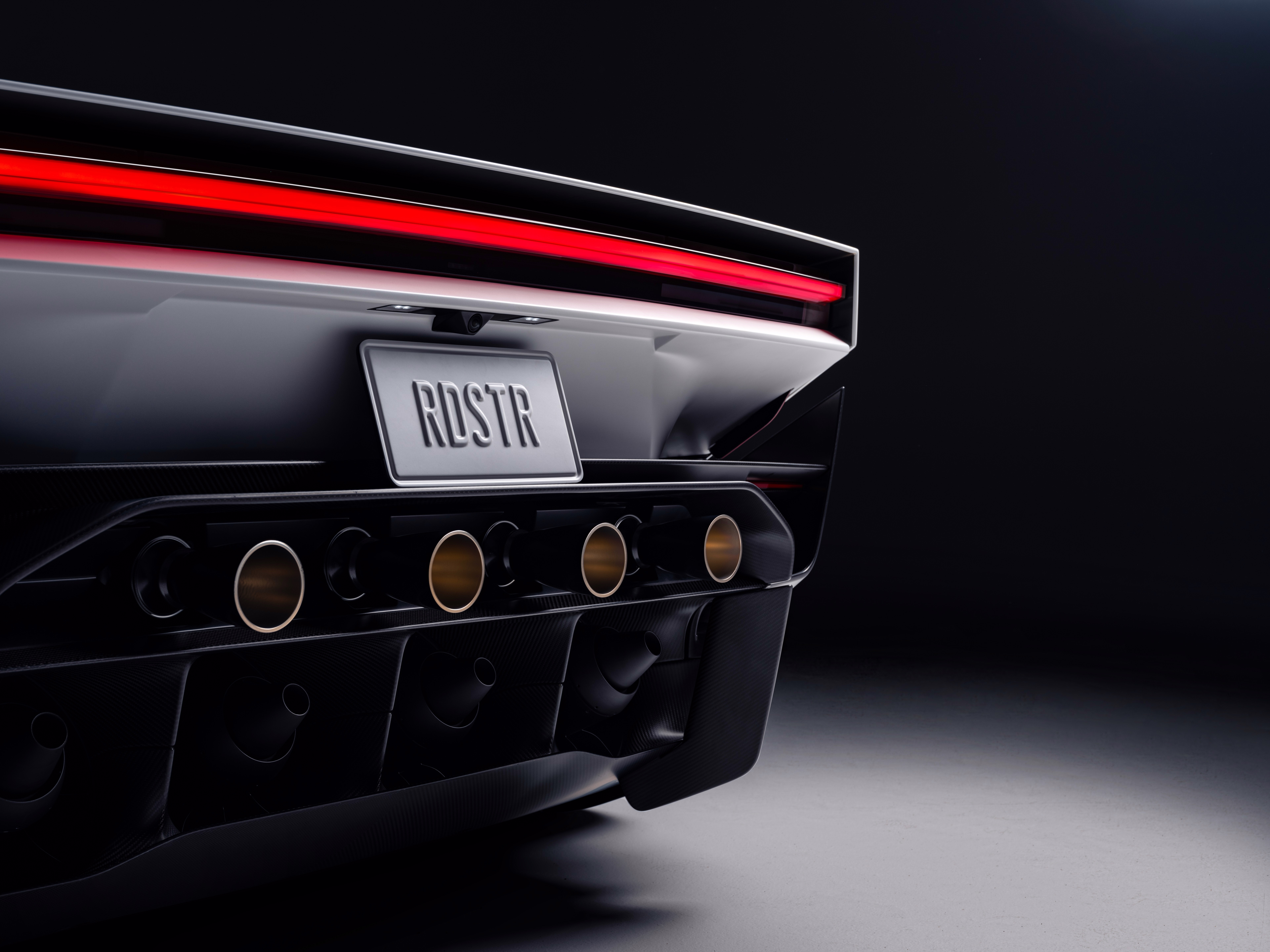 Bocais circulares traseiros do Roadster entre lanterna e difusor