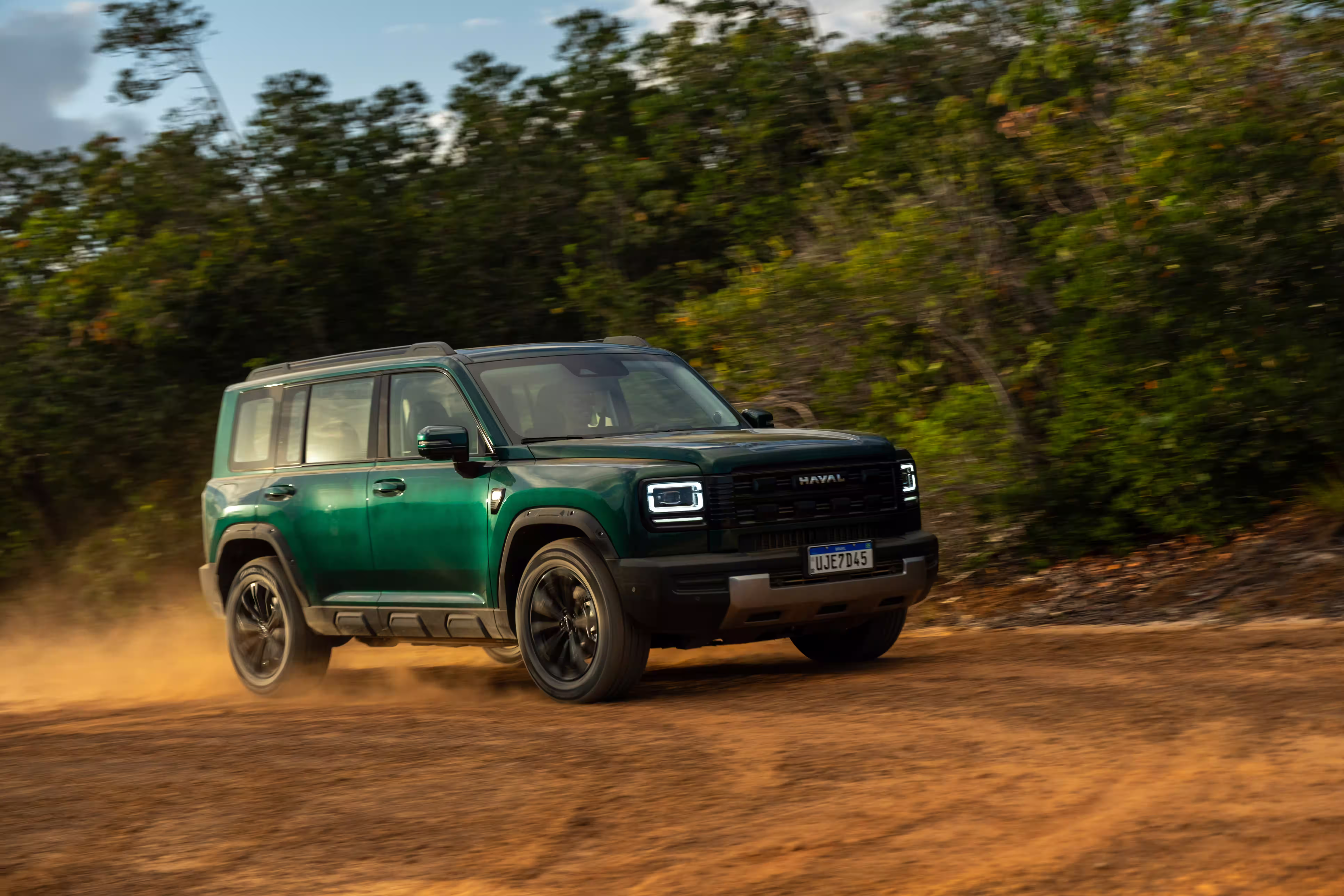 Foto de divulgação do Haval H7 visto de frente em movimento numa estrada de terra.