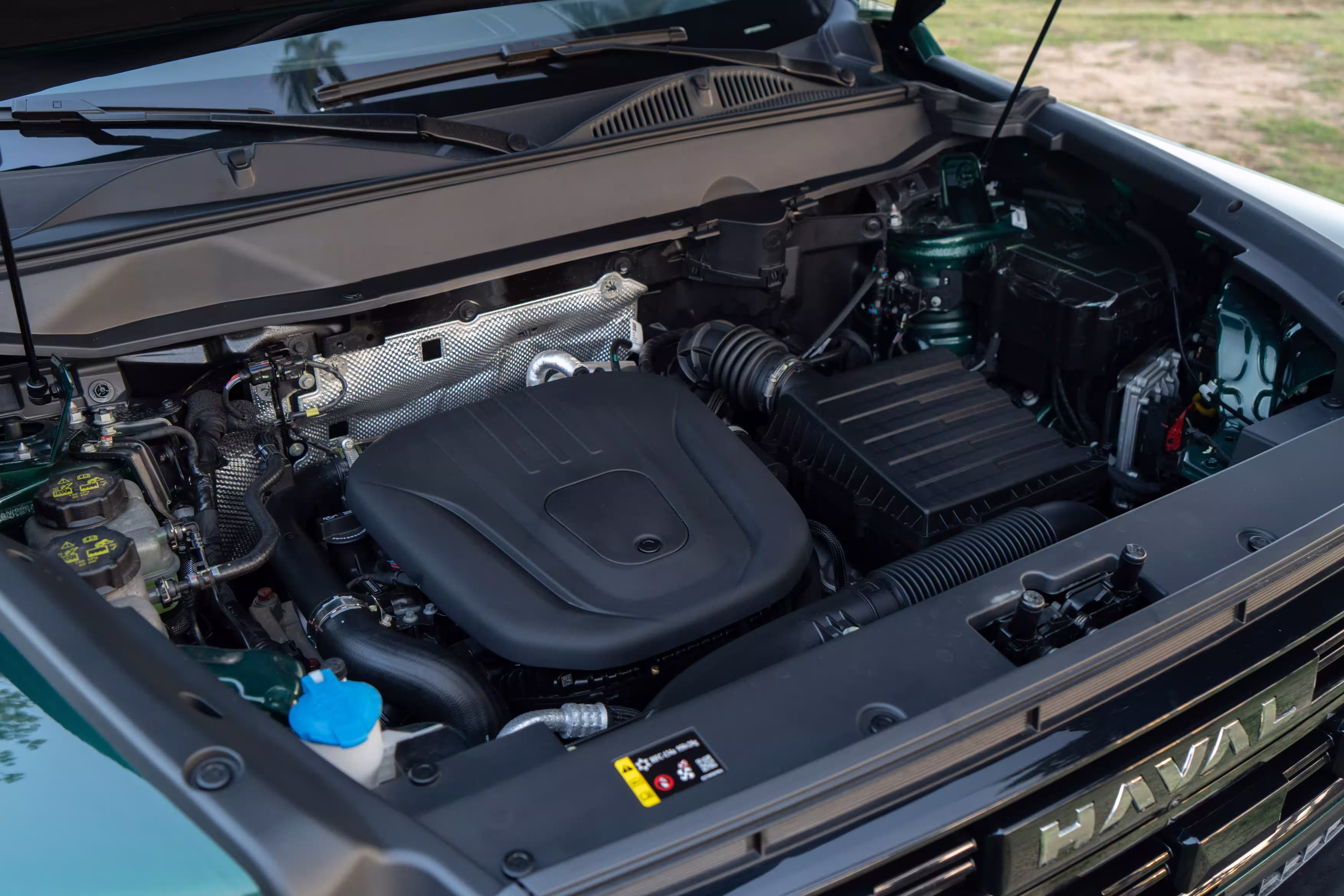 Foto de divulgação: Compartimento do motor do Haval H7 visto em diagonal, com o capô aberto.