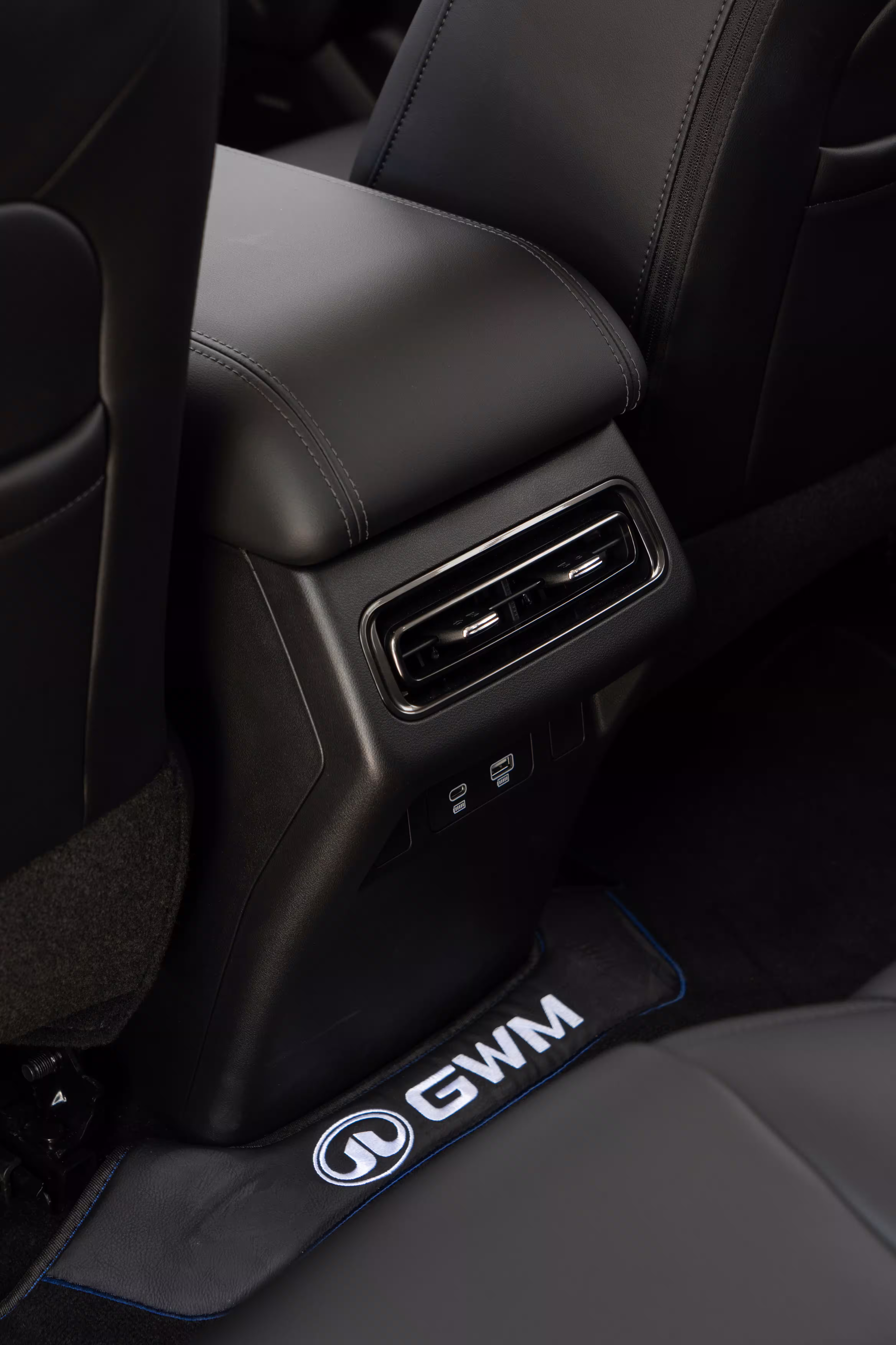 Foto de divulgação: Foto vertical das saídas de ar traseiras do Haval H7, atrás do console.