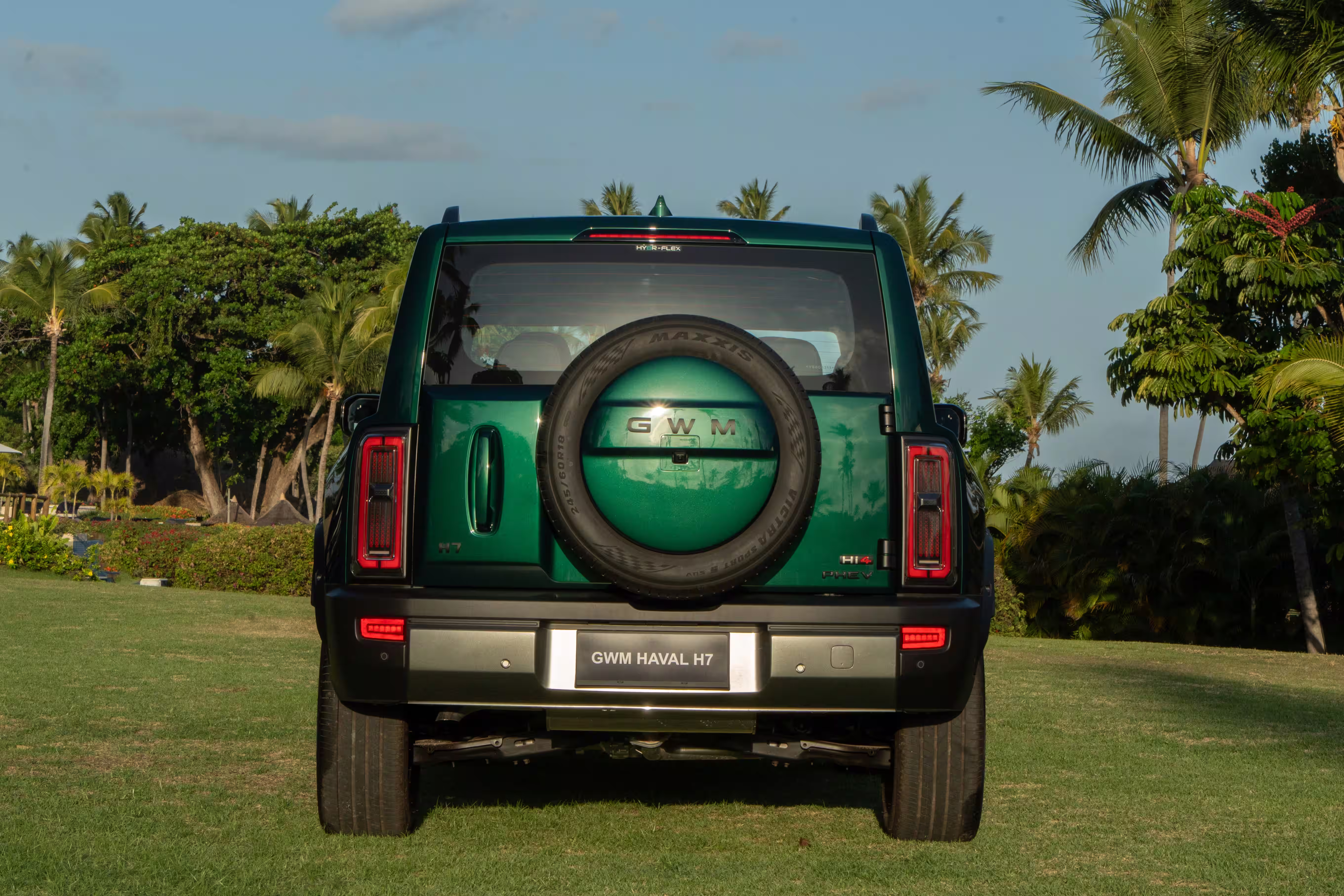 Foto de divulgação: Haval H7 verde visto diretamente por trás, parado num gramado.