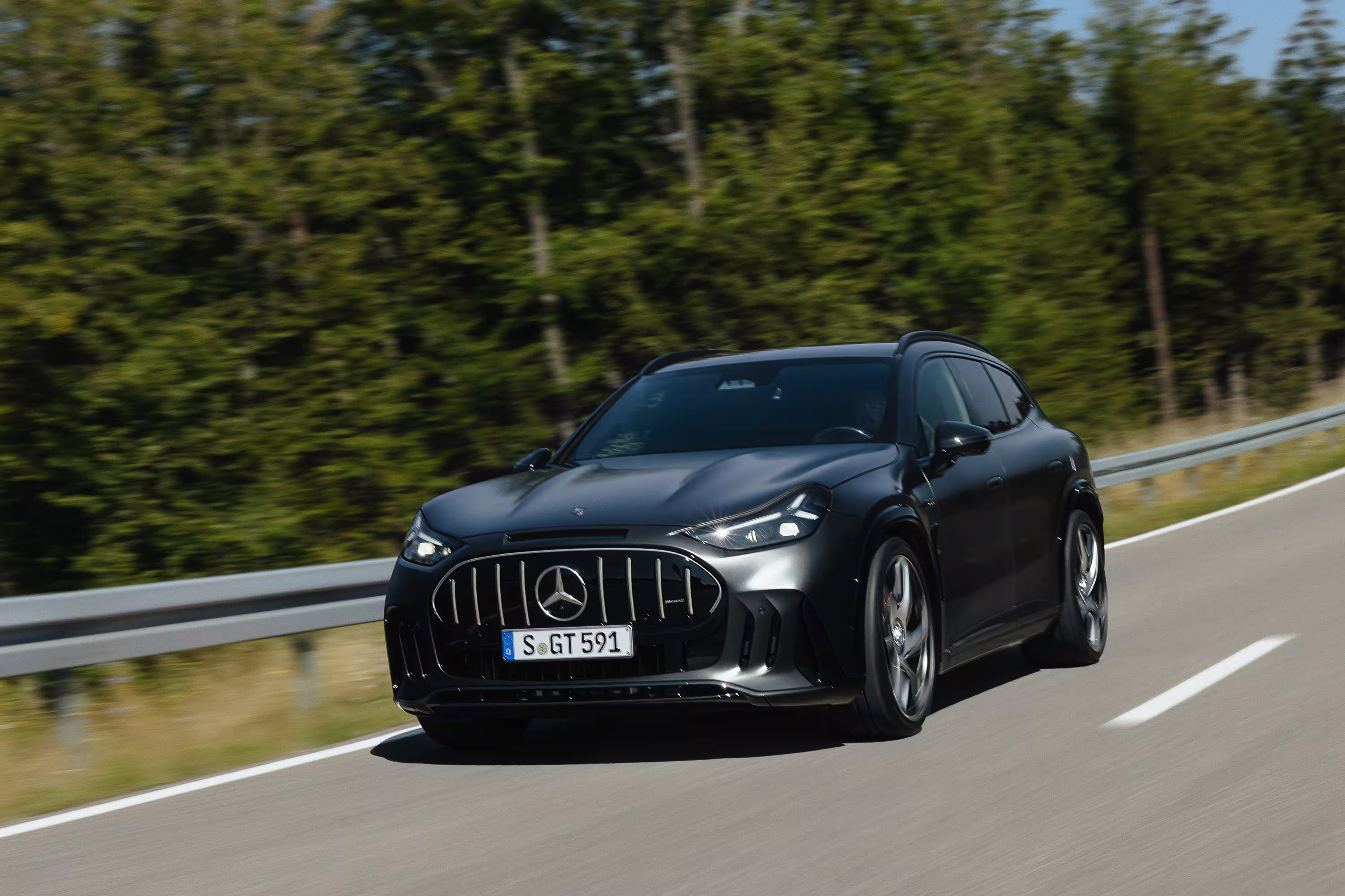 Mercedes-AMG GT SUV cinza circulando diante de uma área arborizada